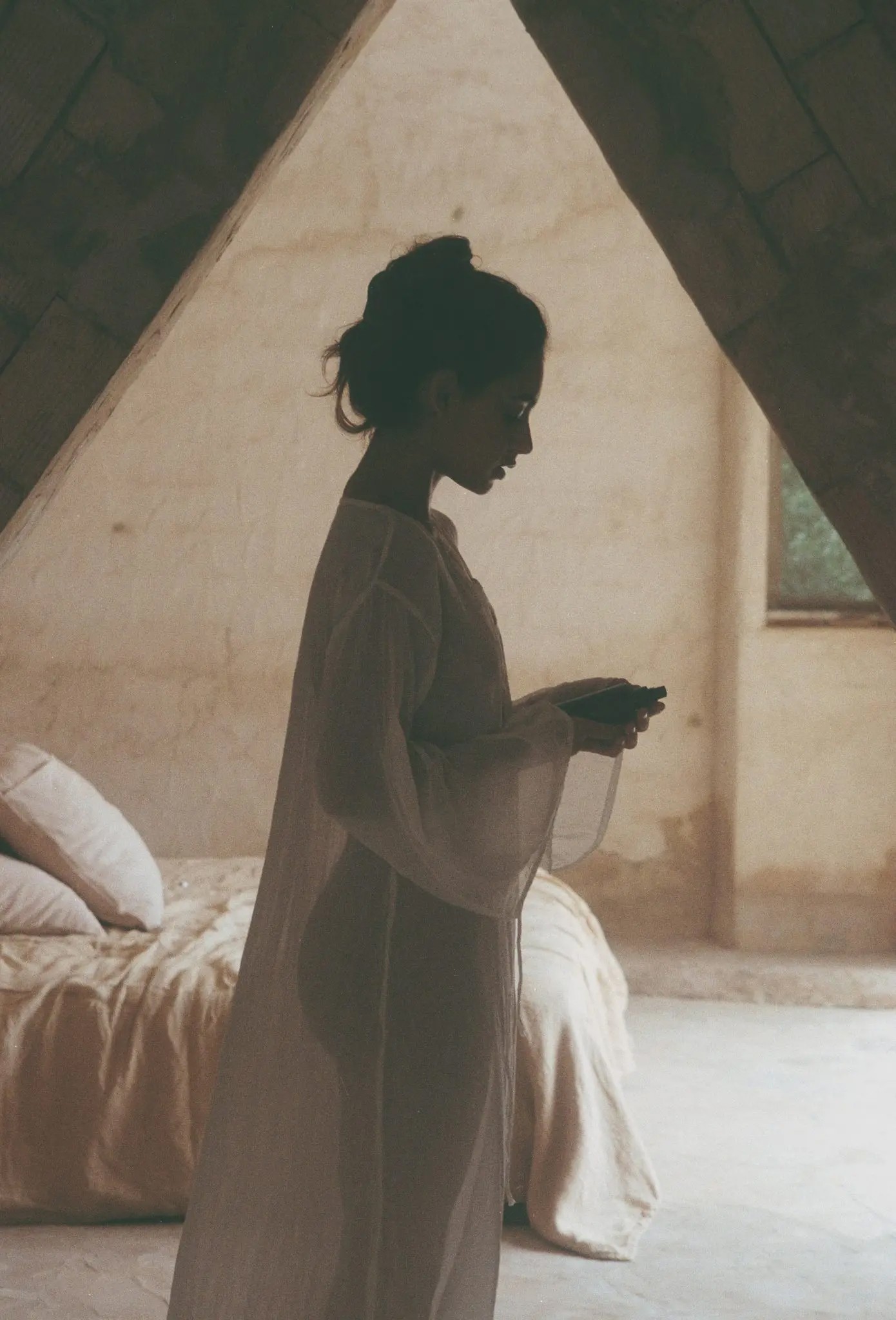 A black and white photo of a person standing behind a frosted glass partition with grooming tools and products in the foreground.