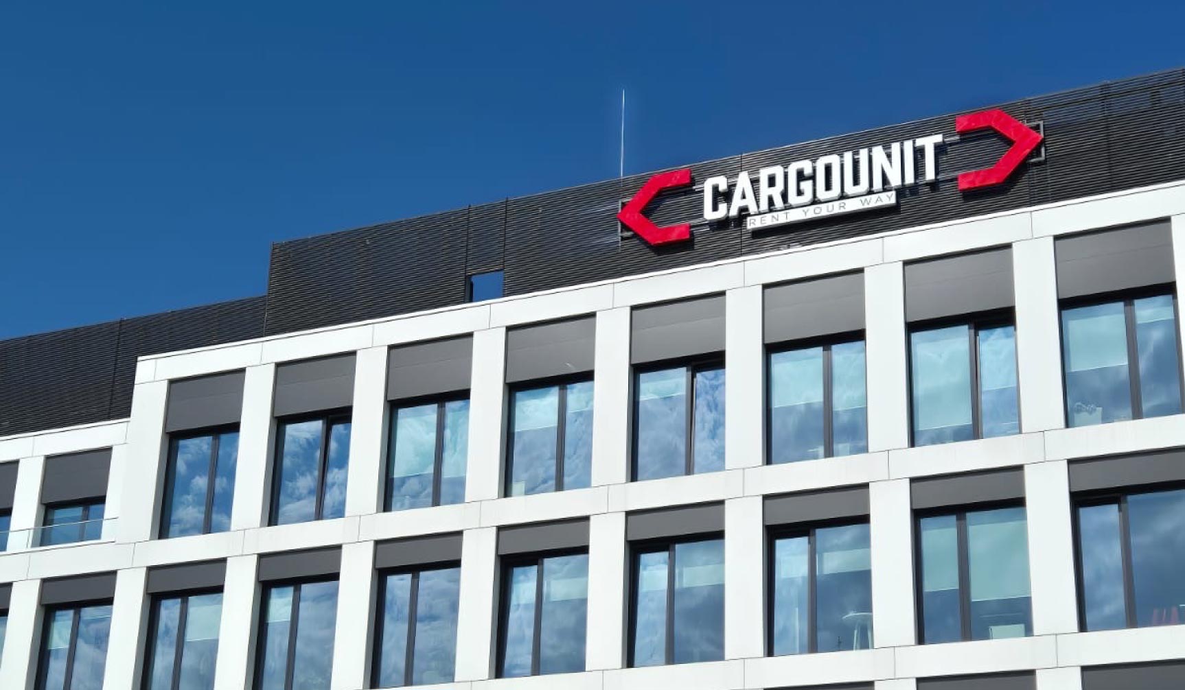 Oznakowanie zewnętrzne siedziby firmy – montaż liter przestrzennych 3D z logo CargoUnit na elewacji biurowca.