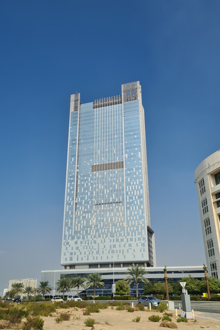 Impressive glass facade of a commercial skyscraper in Motor City. Expert real estate guidance for office acquisitions.