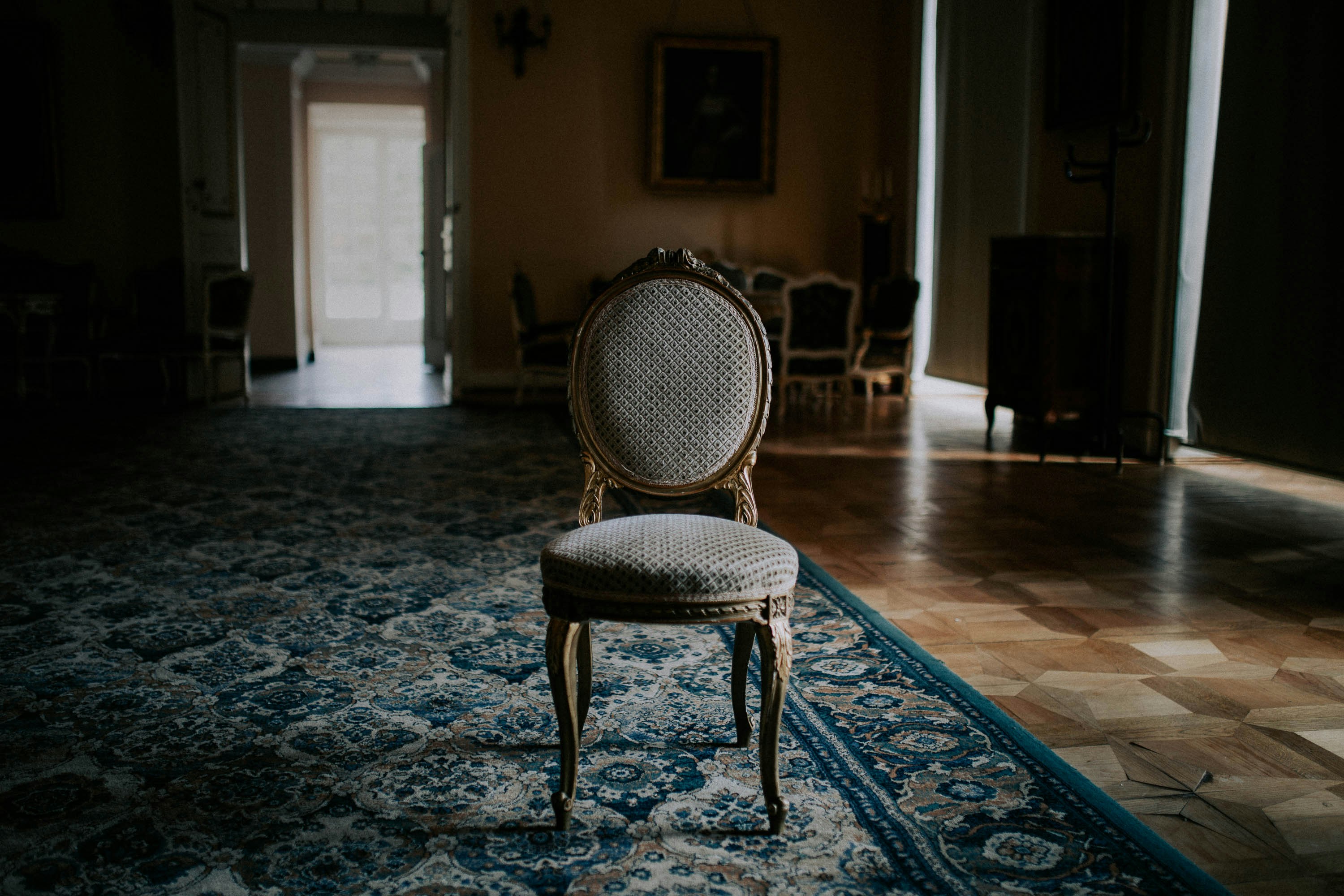 brown wooden chair on blue and white floral area rug