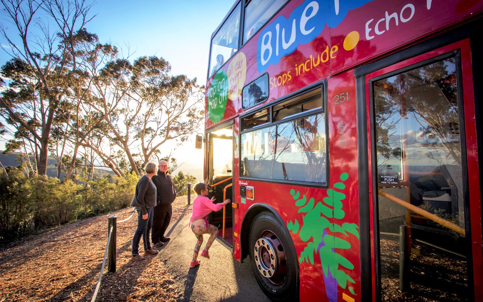 Turisti che salgono su un autobus rosso a due piani a Sydney con viste panoramiche sullo sfondo.
