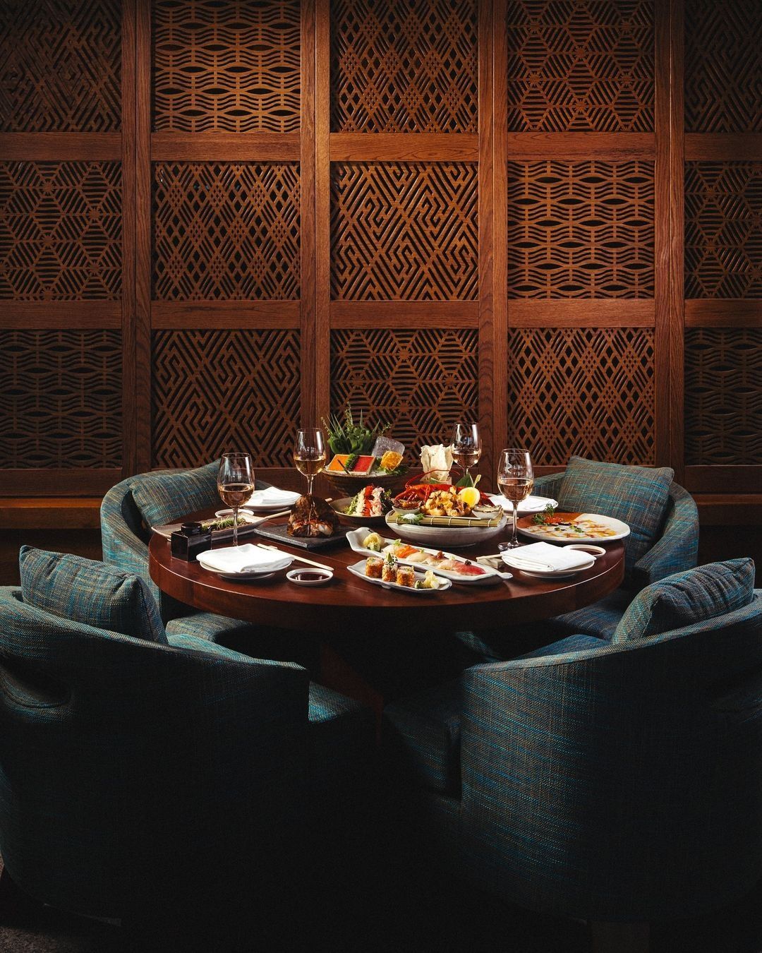 Intimate dining setup with wine and curated dishes, illustrating Dhoom’s commitment to creating warm, welcoming spaces rooted in modern Indian hospitality.