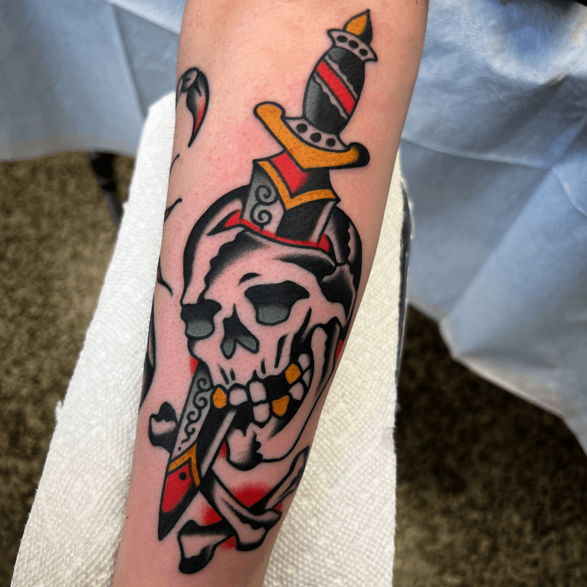 color tattoo of a skull impaled by a dagger