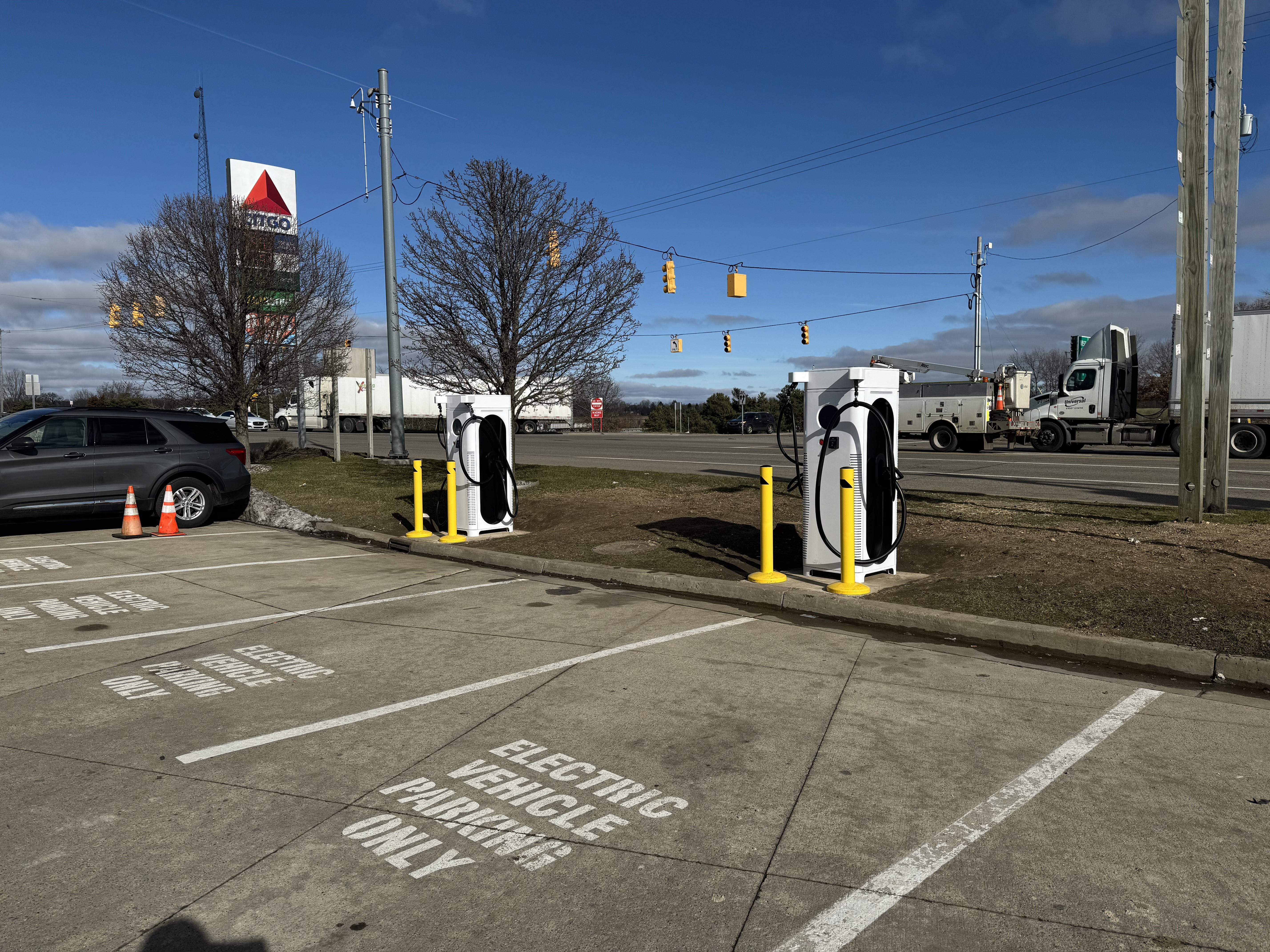 Two C6AM chargers in a parking lot next to a CITGO sign
