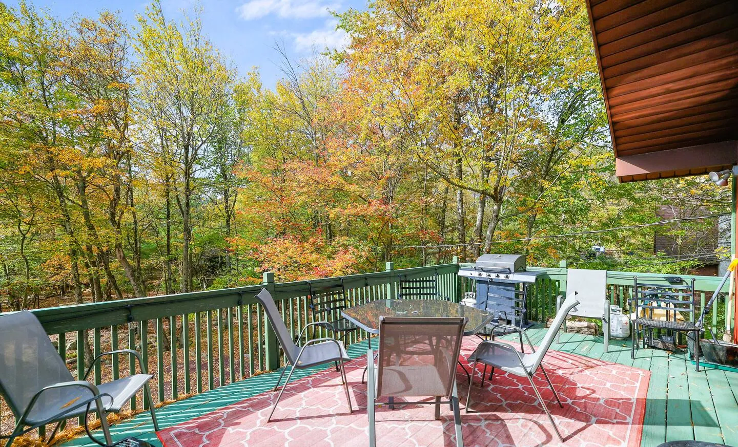 Upper front deck with dining table, chairs and propane grill at RedHawk Chalet, Lake Harmony, PA