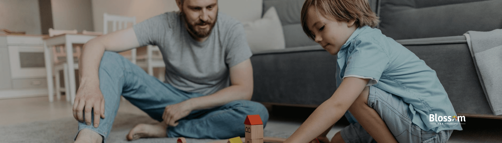 An RBT & autistic child playing with a train set on a carpeted floor at a living room in Virginia.