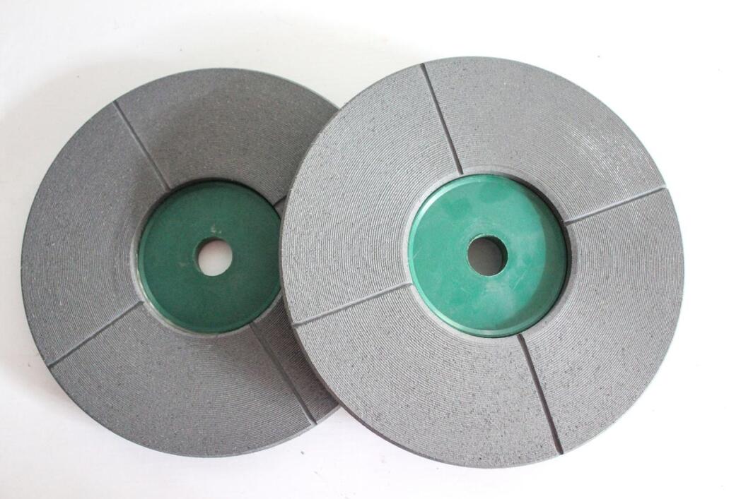 Two gray polishing discs with green centers, displayed flat on a white background.