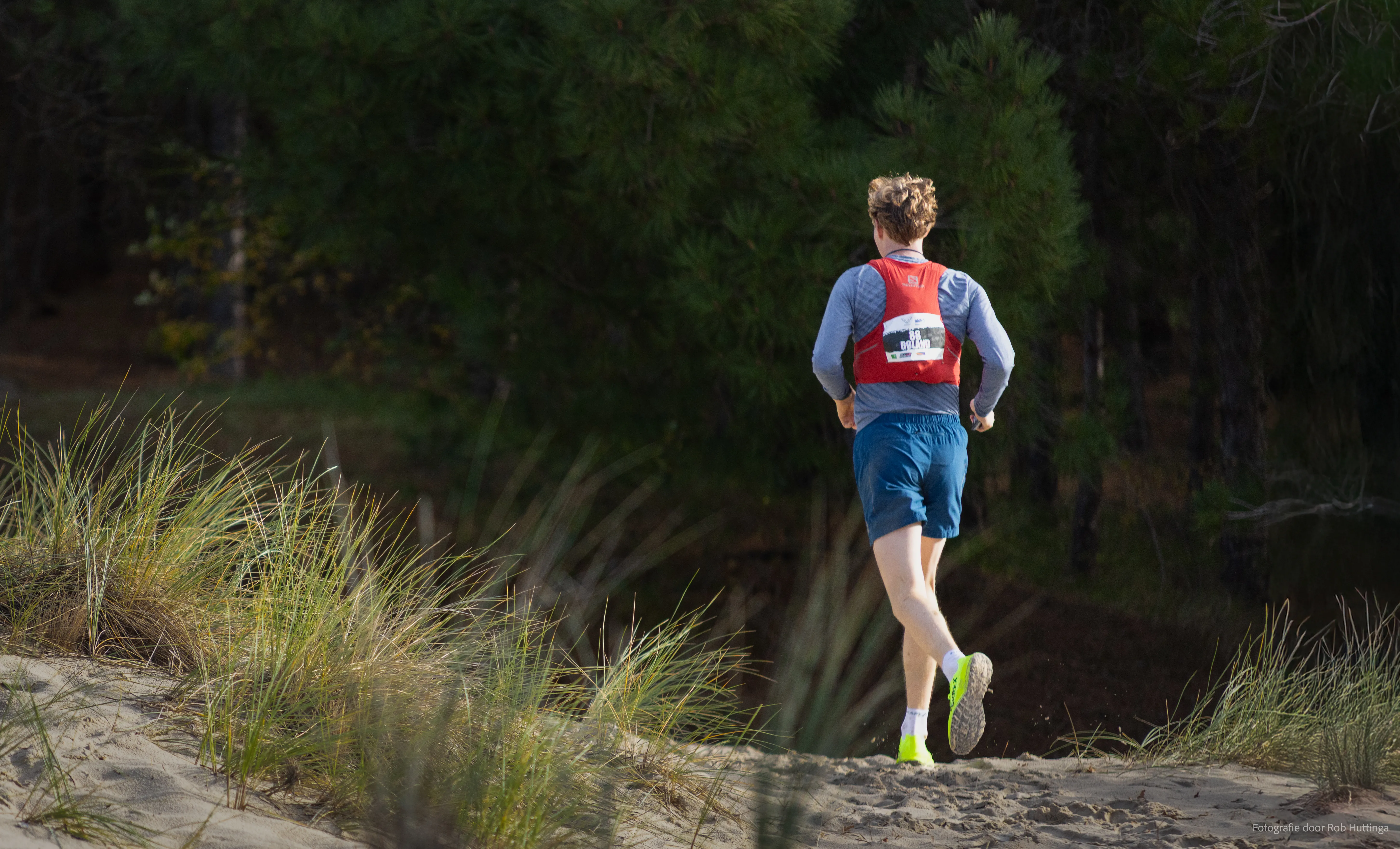 Actiefoto van een deelnemer van mudsweattrails in het bos in in Schoorl