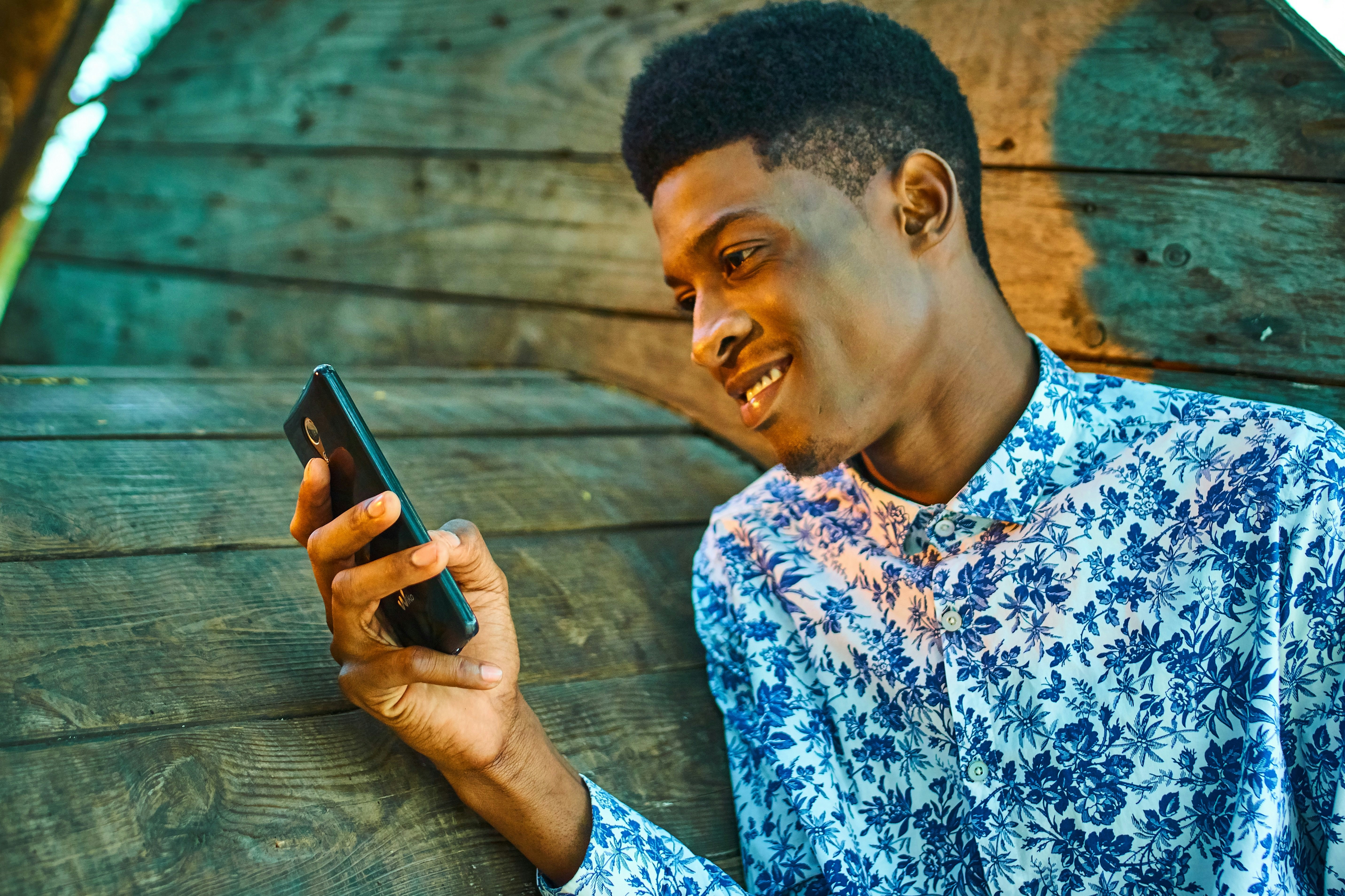 Man die lachend naar telefoon kijkt