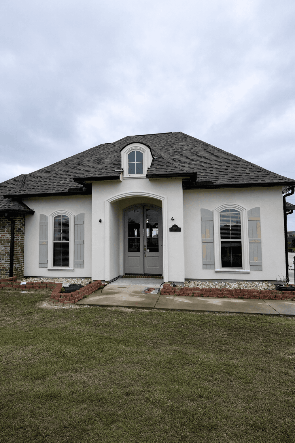 Modern loft interior with greenery, exposed brick walls, large glass windows, and vibrant yellow accents. Inviting atmosphere with natural light.