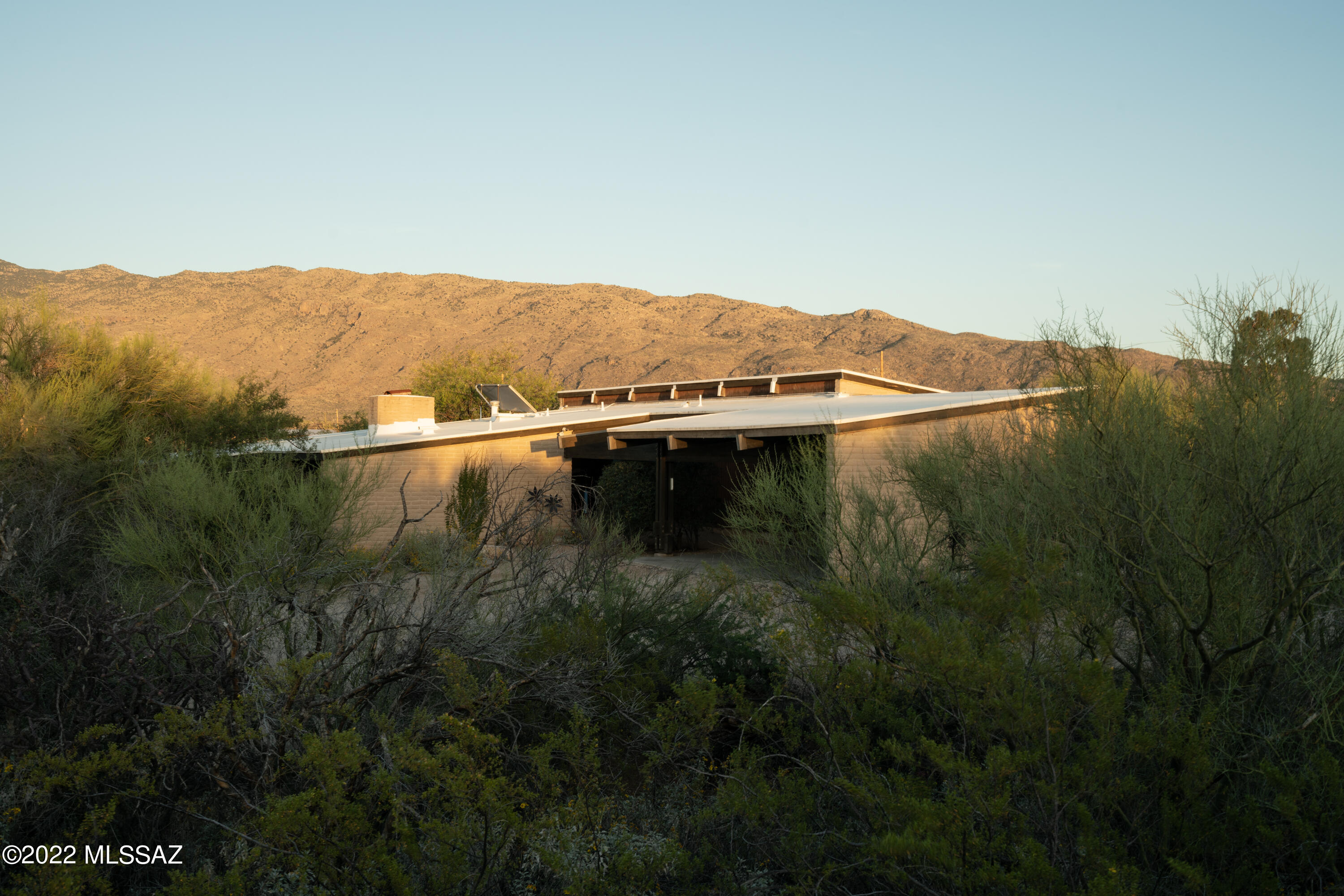 gift registry page with two images: modern villa with infinity pool and person in white dress and straw hat on sandy beach
