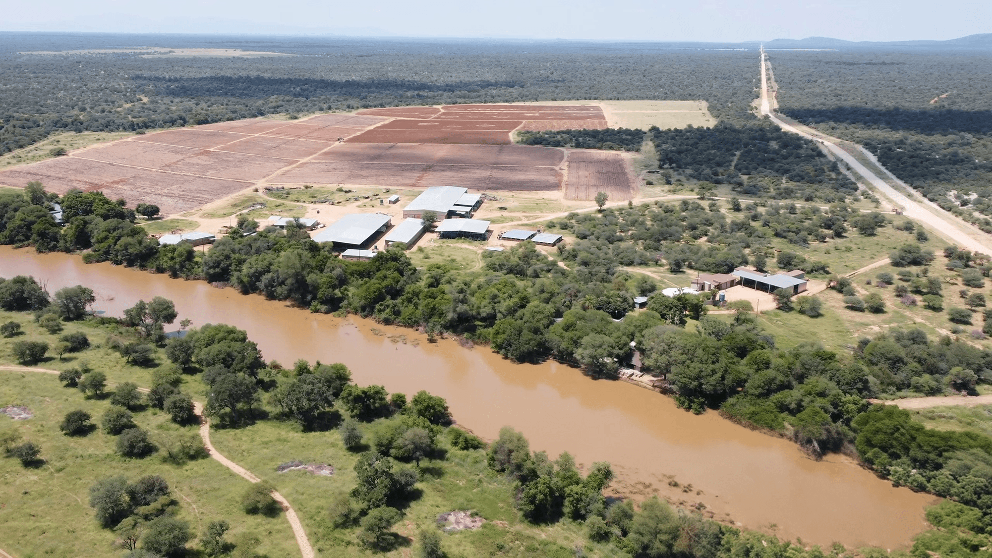 A man and a woman, both in business attire, are engaged in a serious discussion at a table with documents. The setting conveys a professional tone.