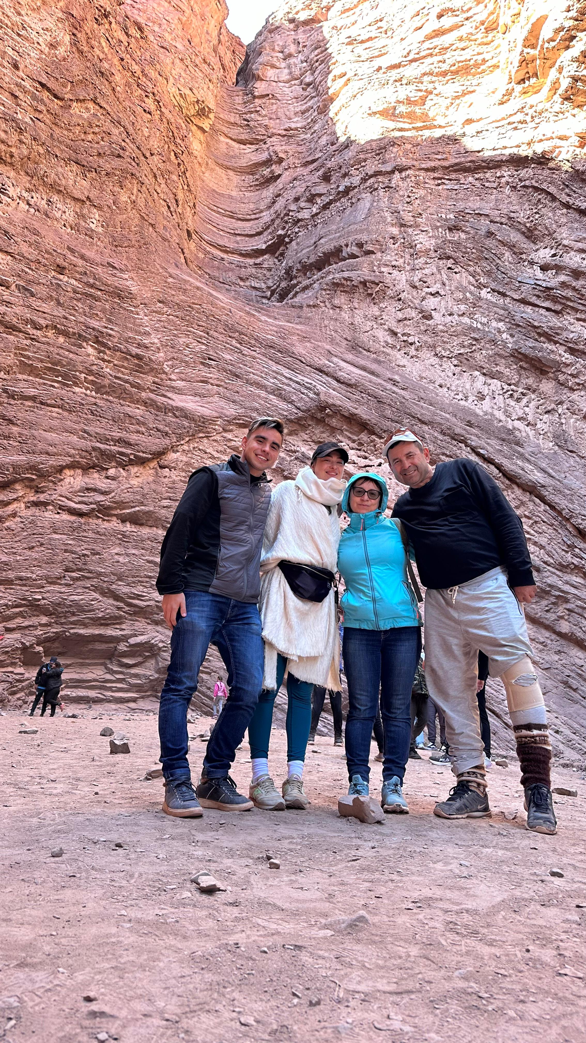 Mujer sentada sobre un tronco frente a una cascada doble en un bosque frondoso de Argentina.