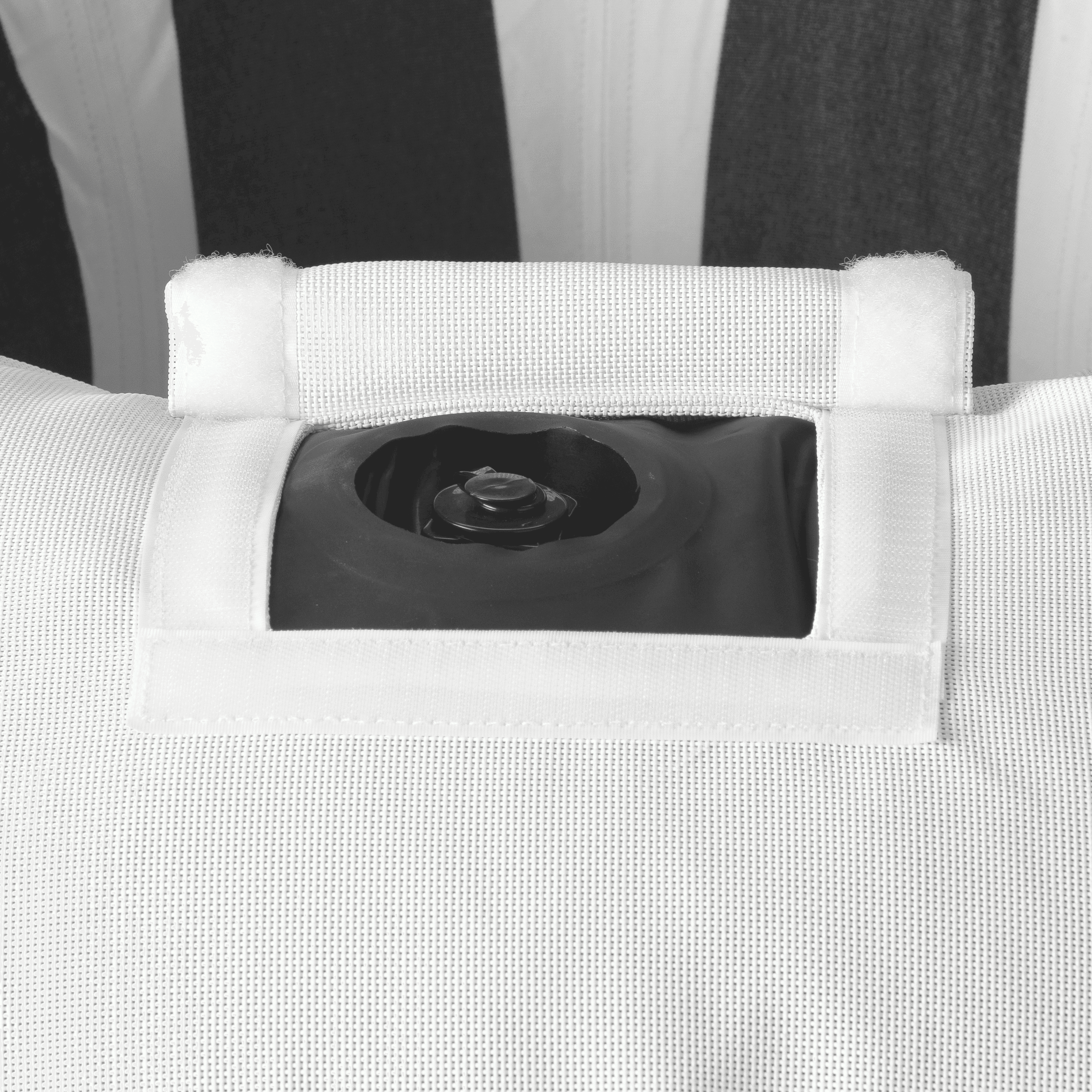Close-up of ring pool float showing black-and-white canvas, inflation valve, and colour-matched zipper