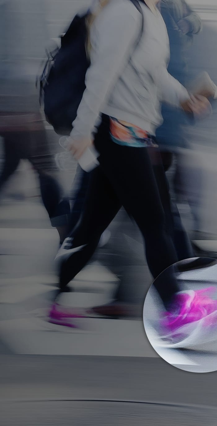 A busy high-street scene with blurry people and an overlay on a persons trainer suggesting computer vision