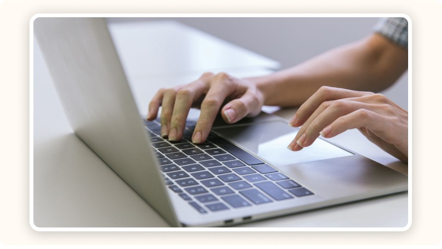 Hands typing on a laptop