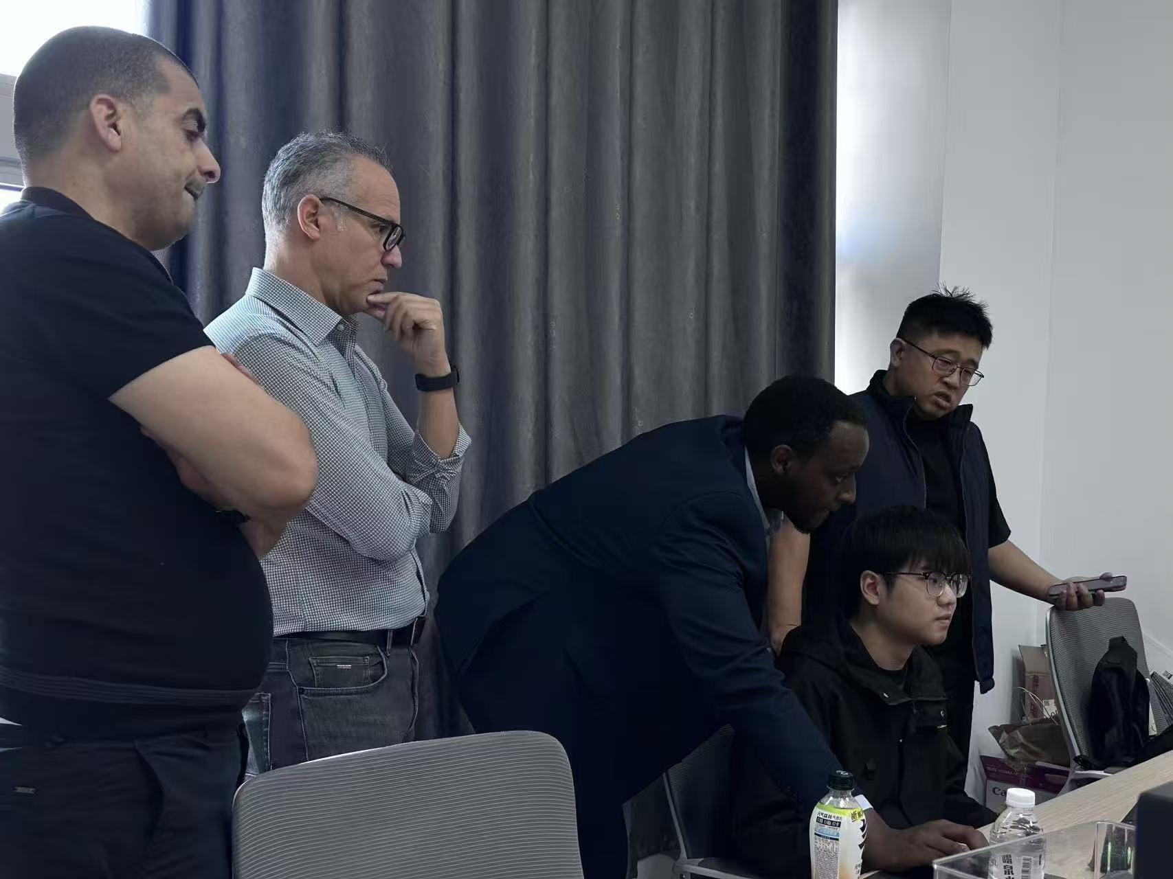 Team of three employees having a meeting at a table in a bright modern office.