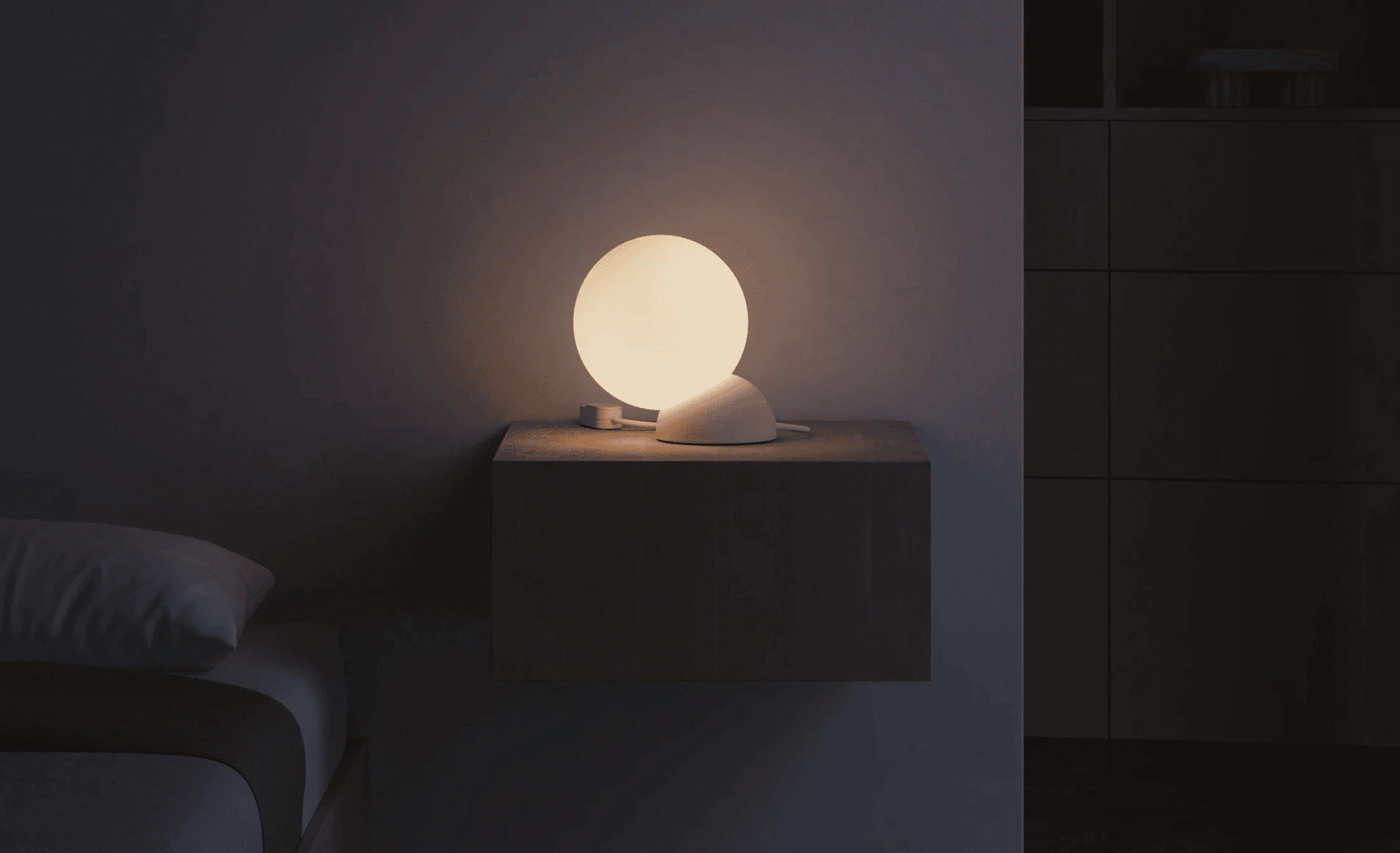 A spherical table lamp glowing in a dark interior.