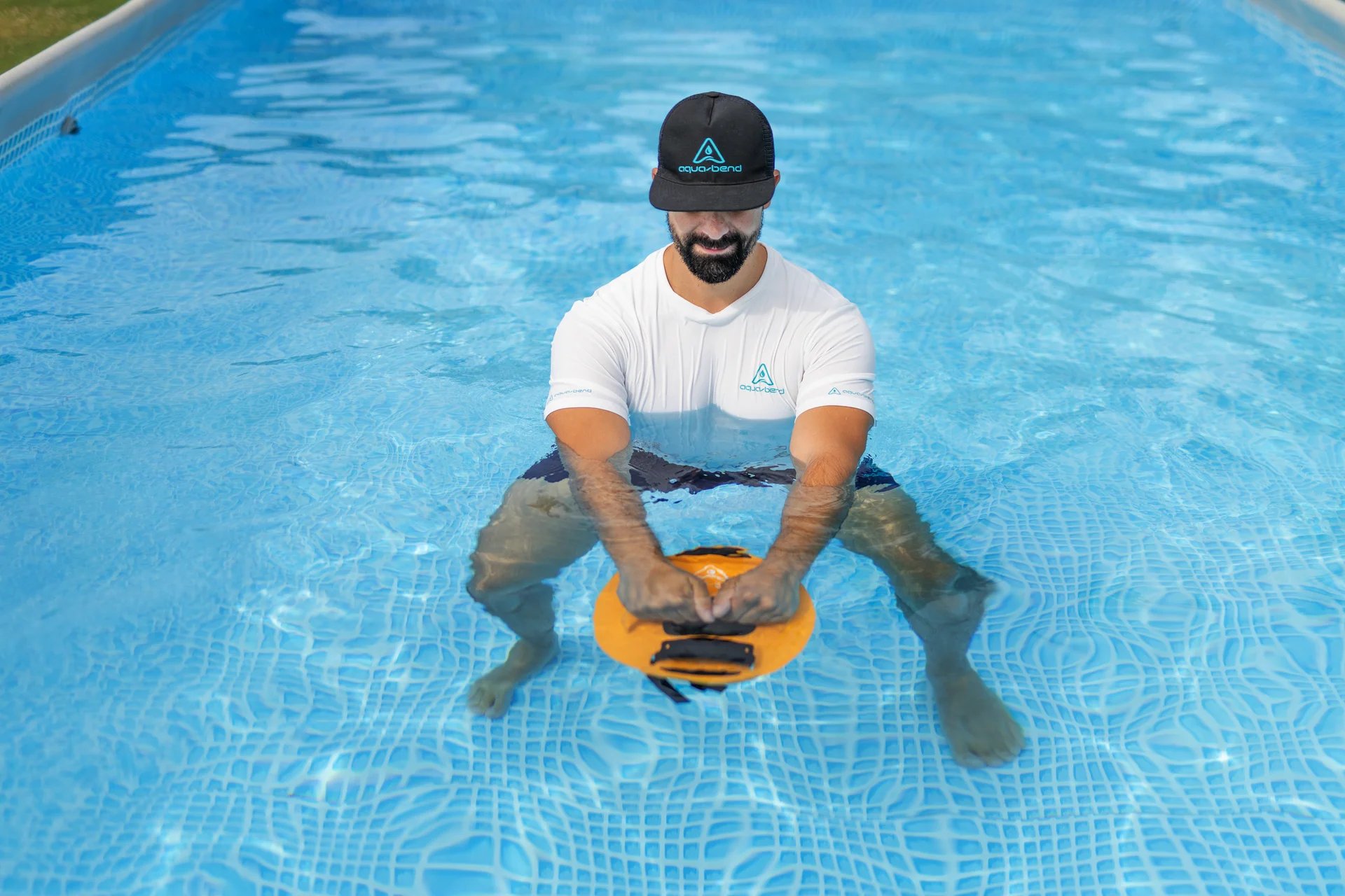 Man performing a kettlebell-style Aqua-Bend swing in water using both hands on the disc