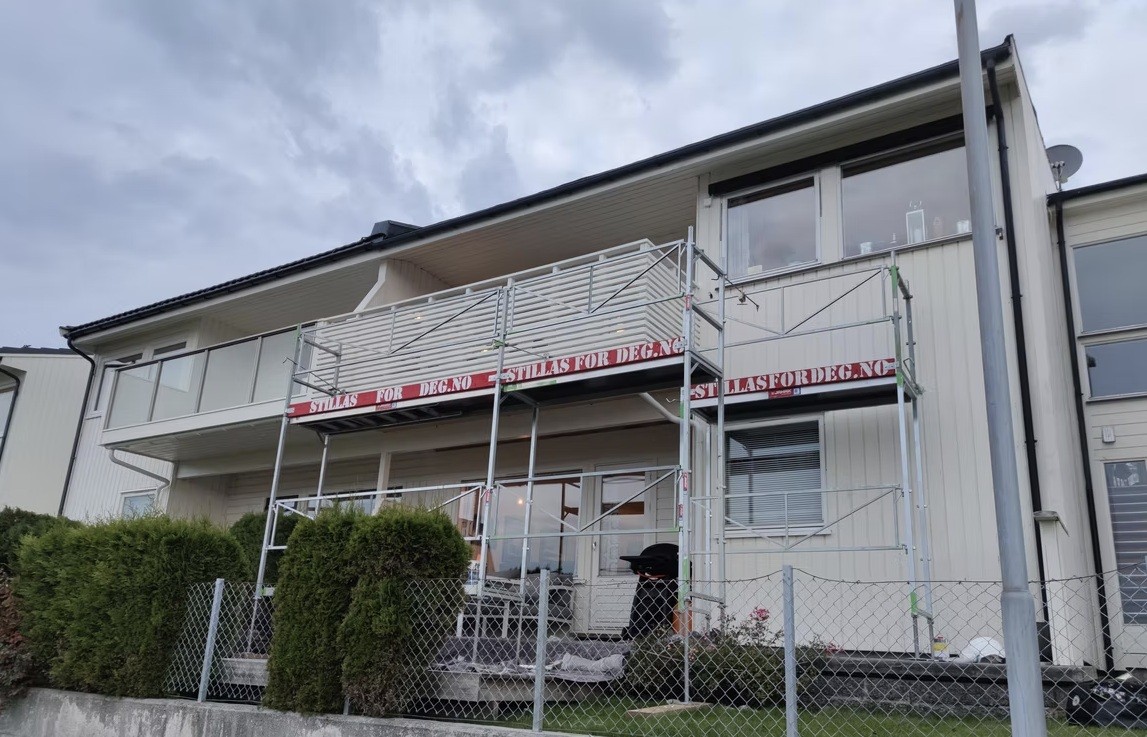 a man in a yellow shirt is working on a roof