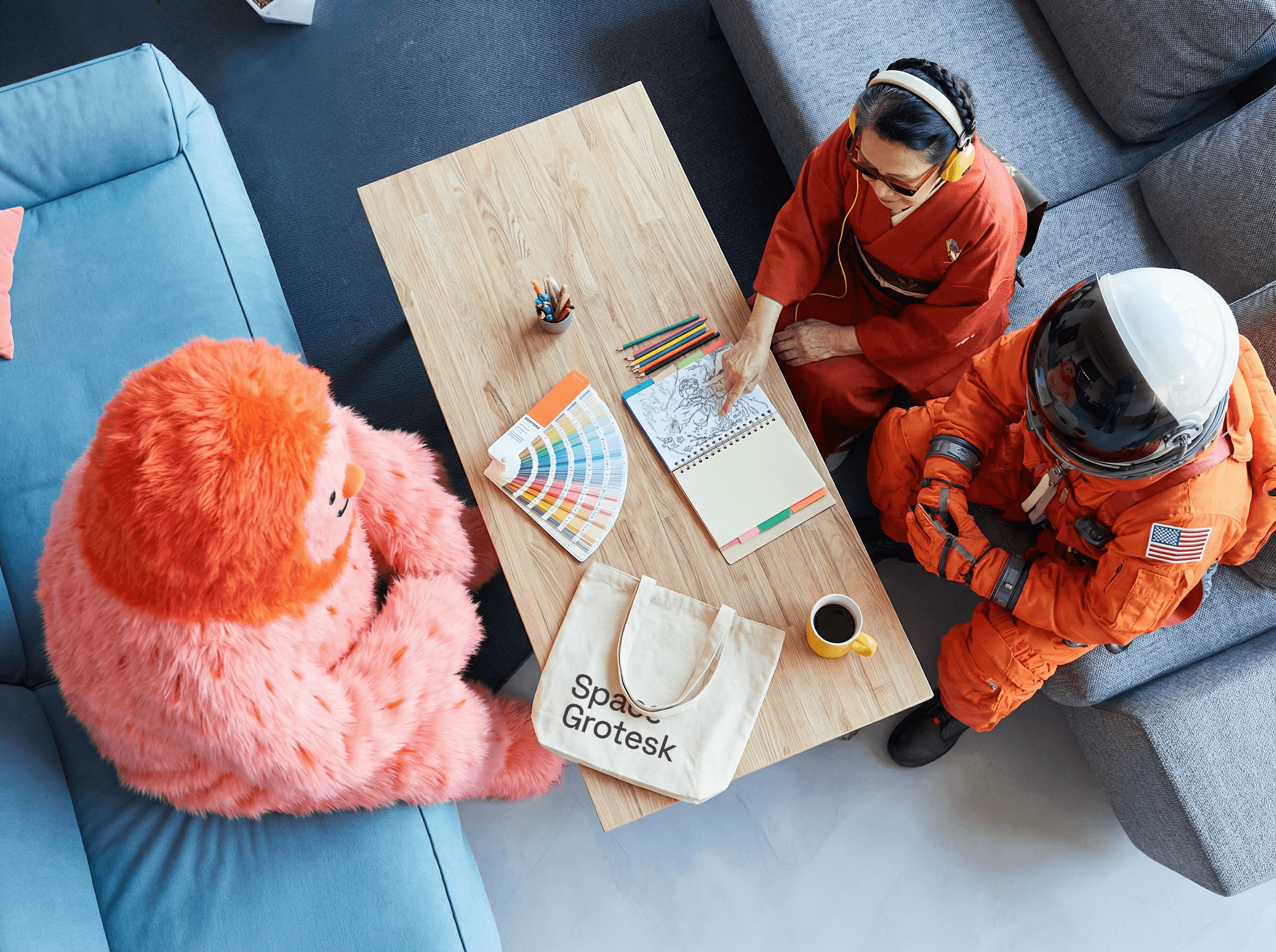 Three people sitting on a couch in a room looking at mobile devices