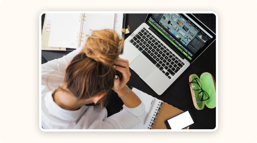 A woman stressed at her laptop, reviewing site performance data — highlighting technical SEO issues.