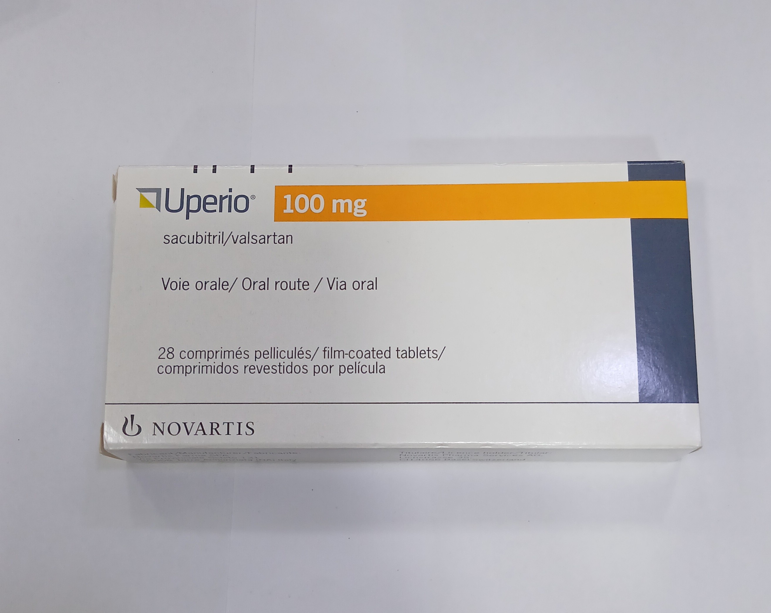 White and orange cardboard box packaging containing 28 film-coated tablets arranged in four rows of seven, with printed text in multiple languages indicating dosage and administration route.