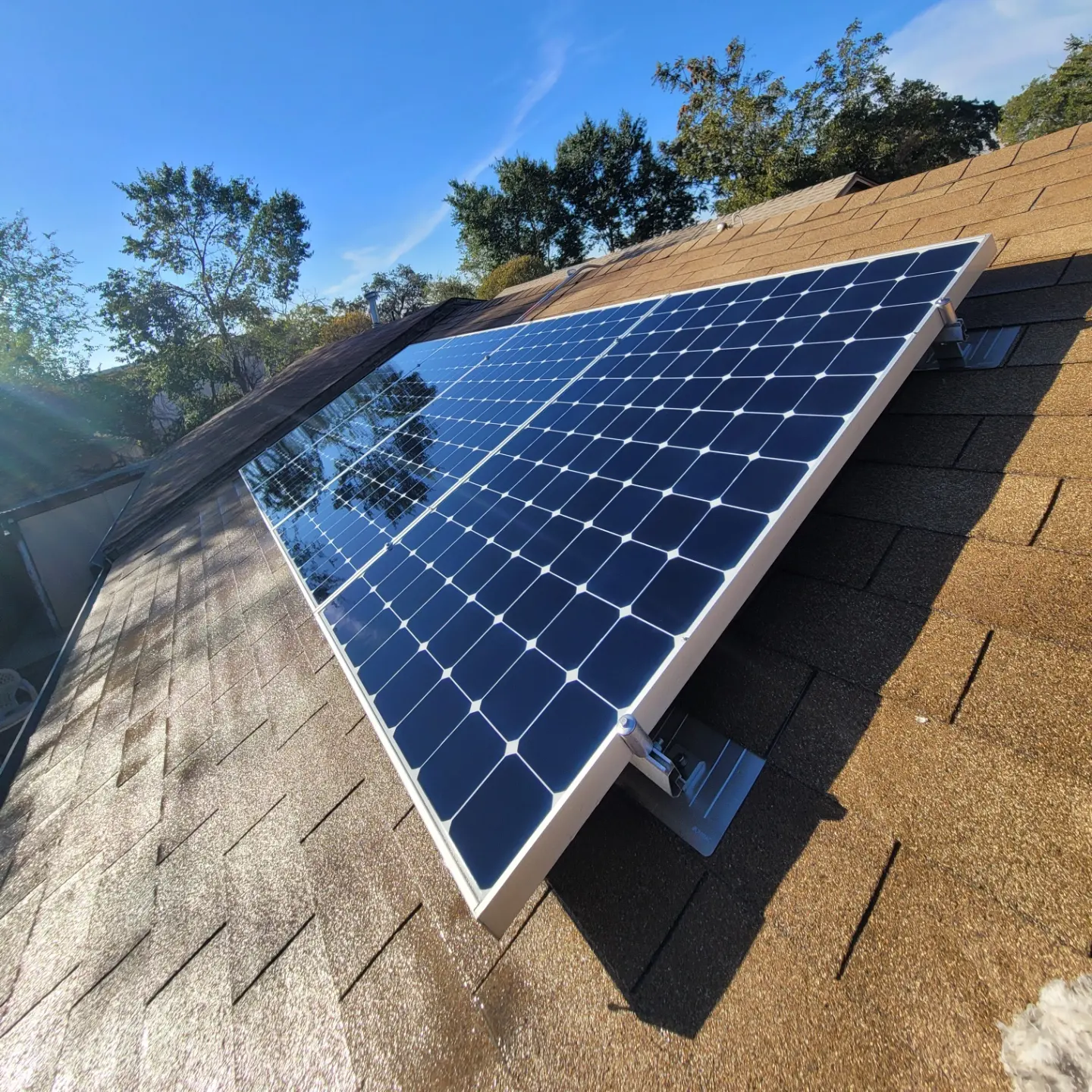 Tilted solar array on a tile roof under blue sky | Premier Solar Service