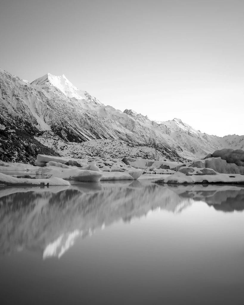 Clear reflections of snowy mountains as the sun rises over Mt Cook/Aoraki New Zealand. A very popular destination for private jet charter passengers