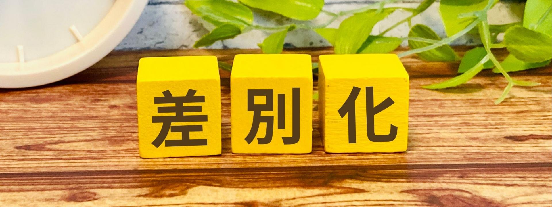 差別化という言葉が書かれた黄色いブロックのある木製テーブルの画像