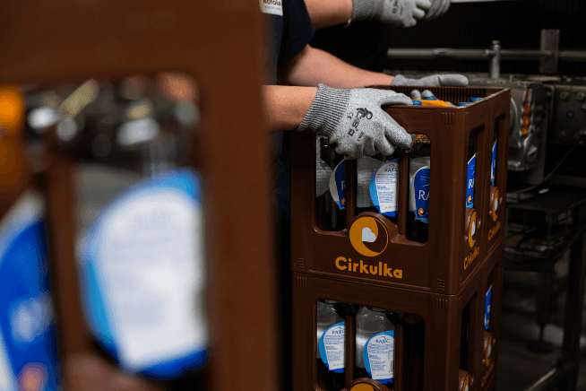 Cirkulka logo and visual system applied to Kofola returnable bottles and crates