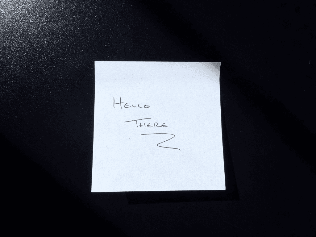 A white sticky note with blank ink text that reads "Hello There" in all caps