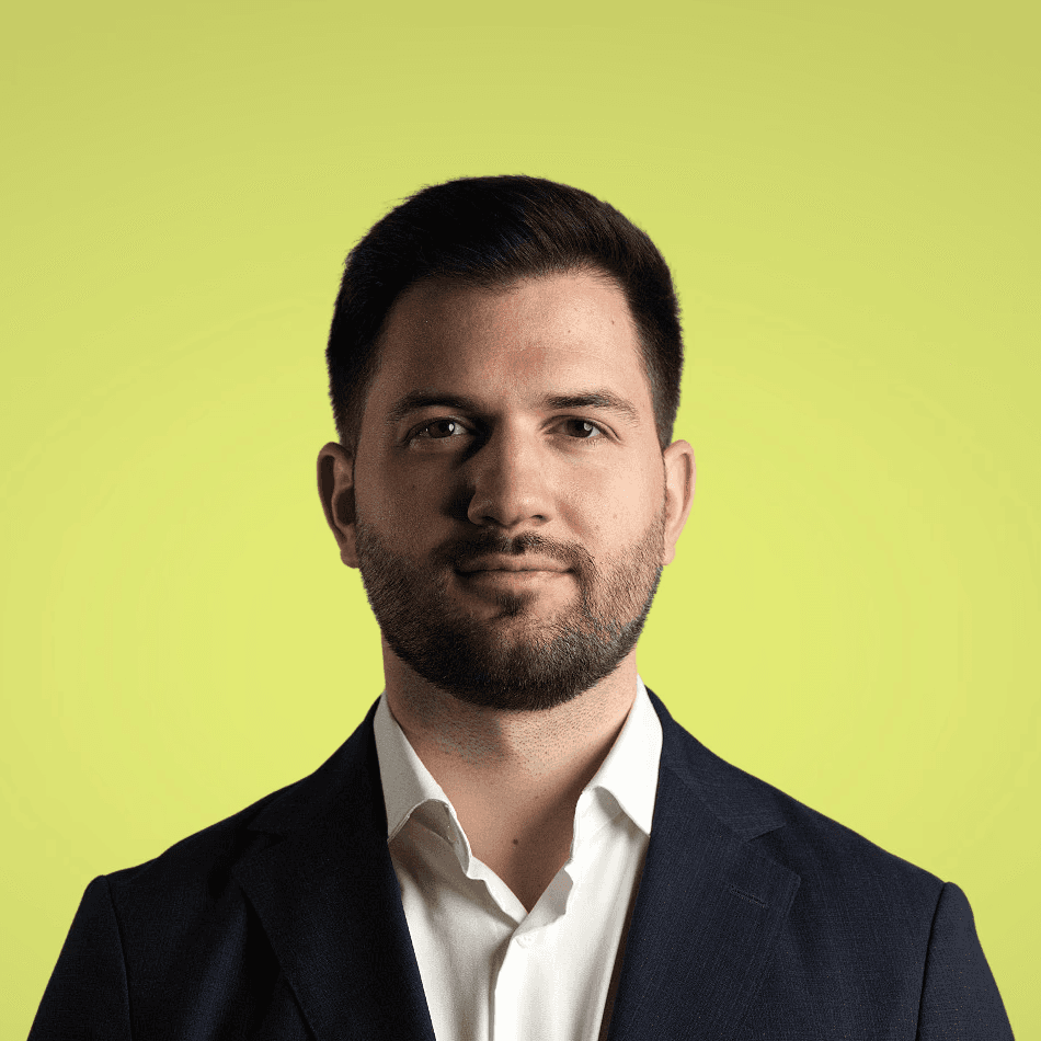 A young person with long, wavy hair sits in front of a plain background, looking directly at the camera.