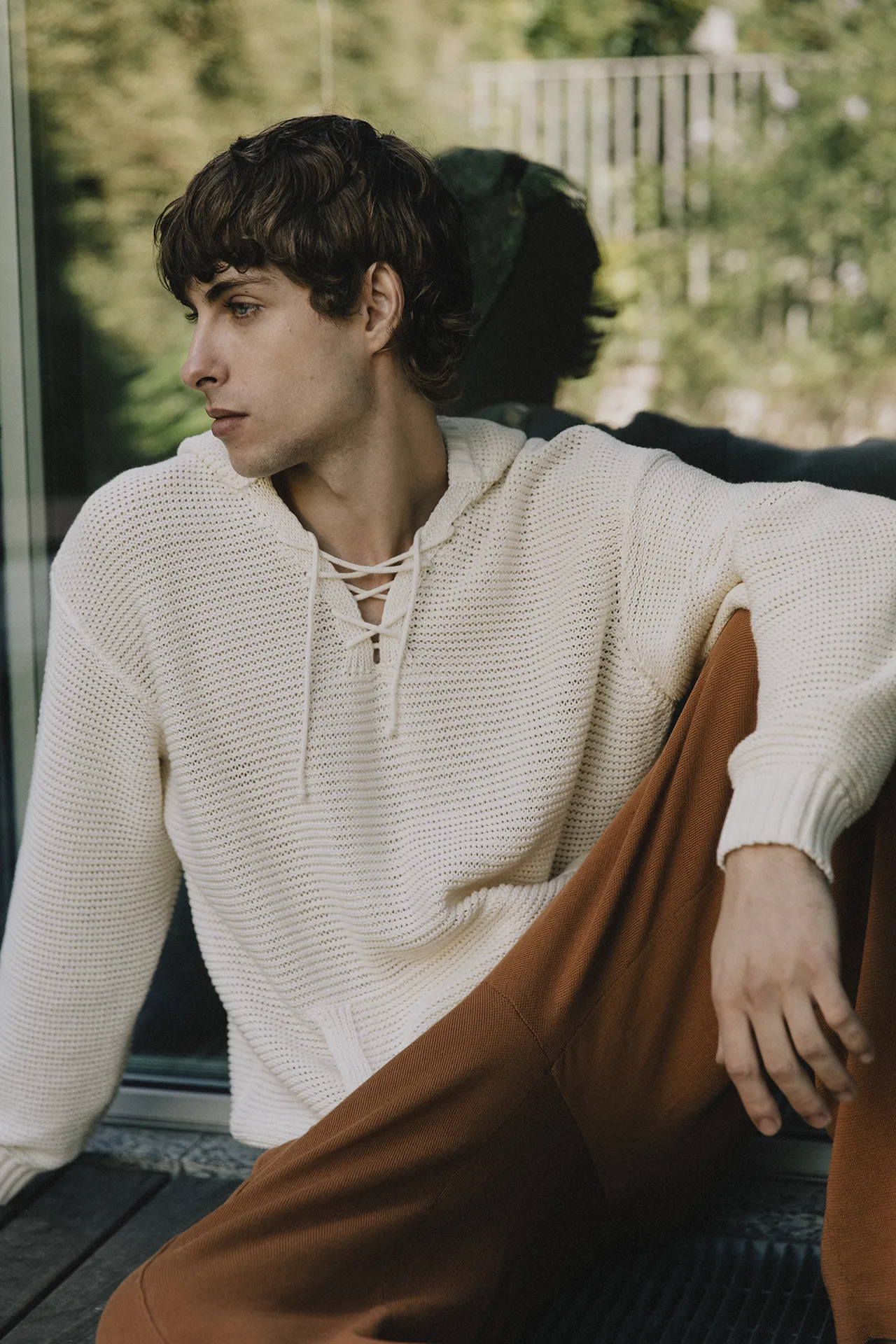 Close-up of Annapurna SS26 collection cream waffle-knit hoodie featuring a drawstring neckline and ribbed cuffs.