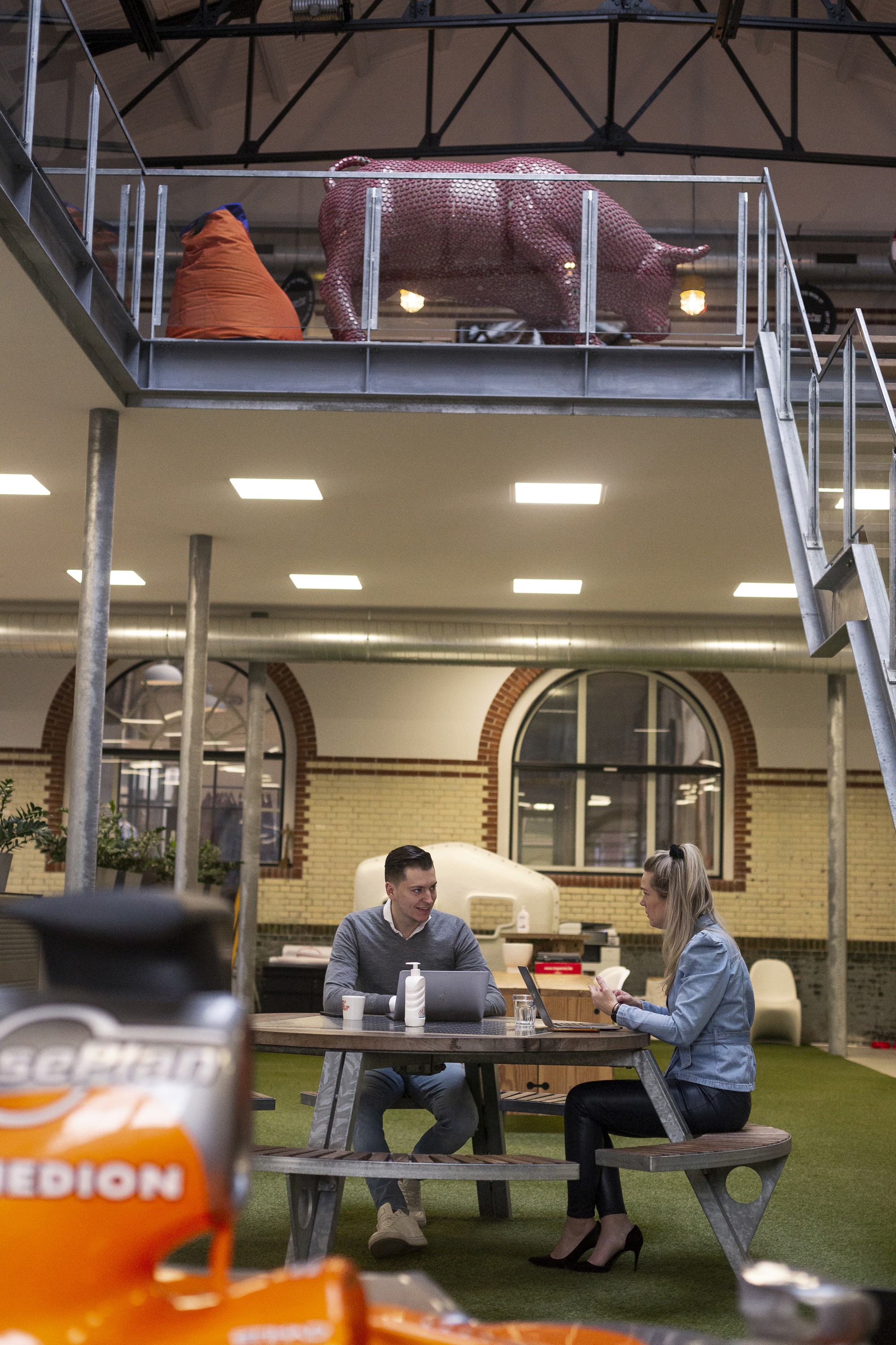 two people meeting at the picnic table that is inside because it is an office