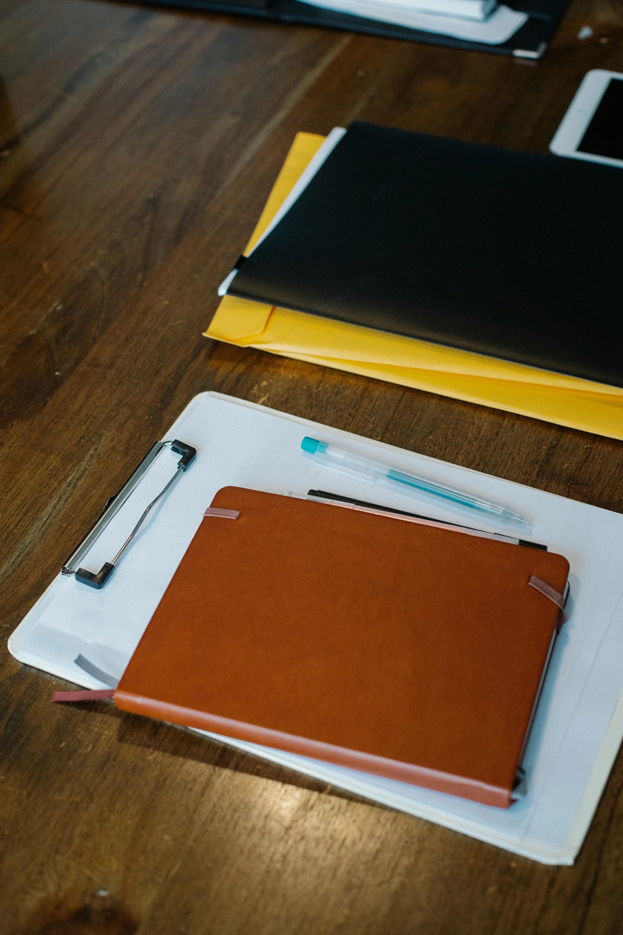 a pile of clipboards on a wooden table