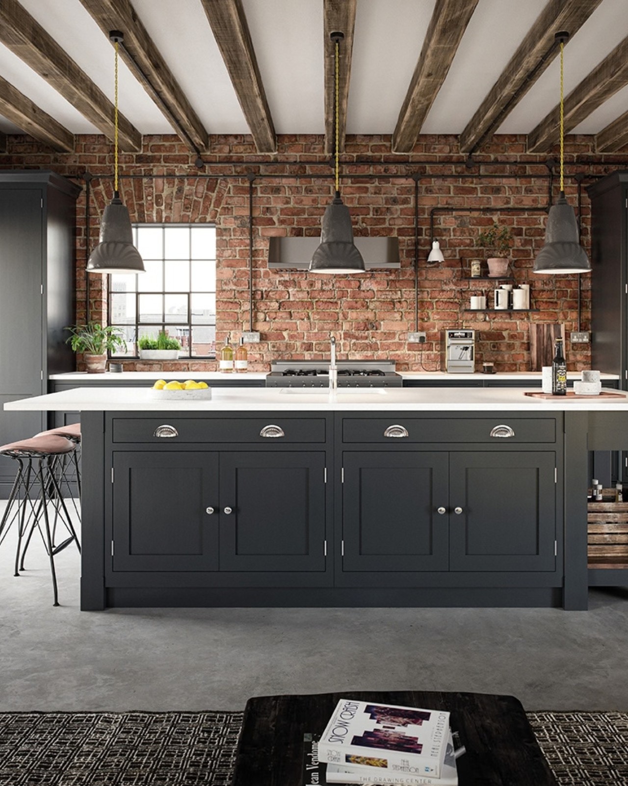 Dark painted kitchen island against an exposed brick wall