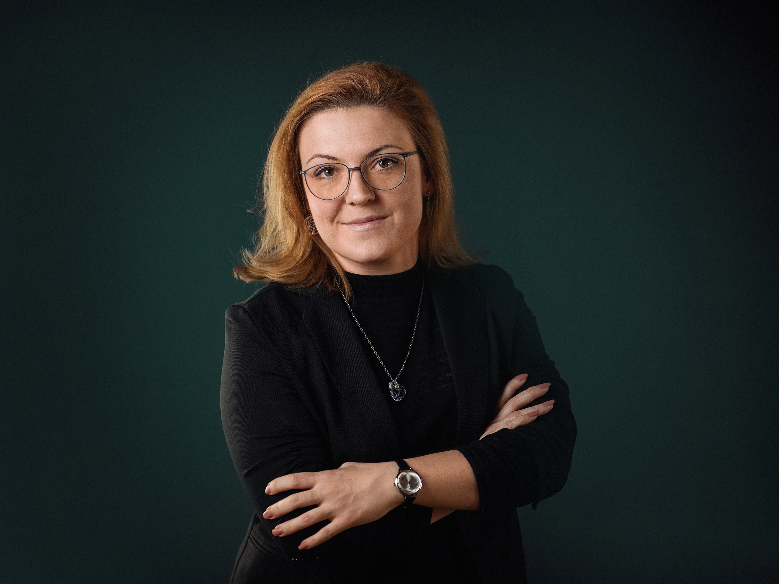 Devojka sa narandžastom kosom pozira za portret ispred zelene pozadine