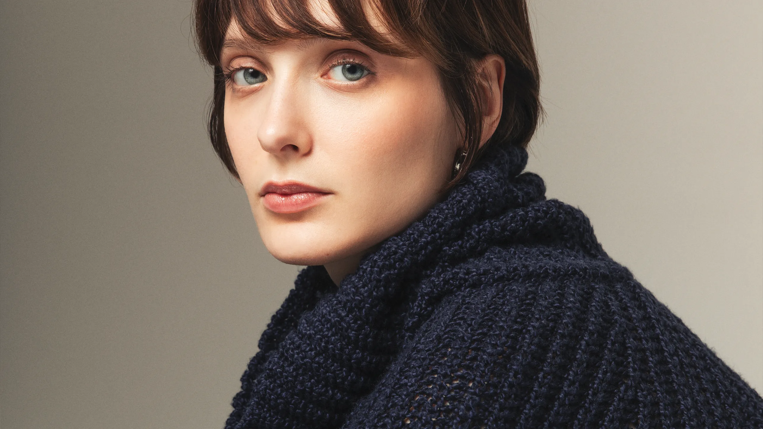 Portrait of a woman wearing a navy textured cashmere sweater – Aida Barni FW25/26 campaign.