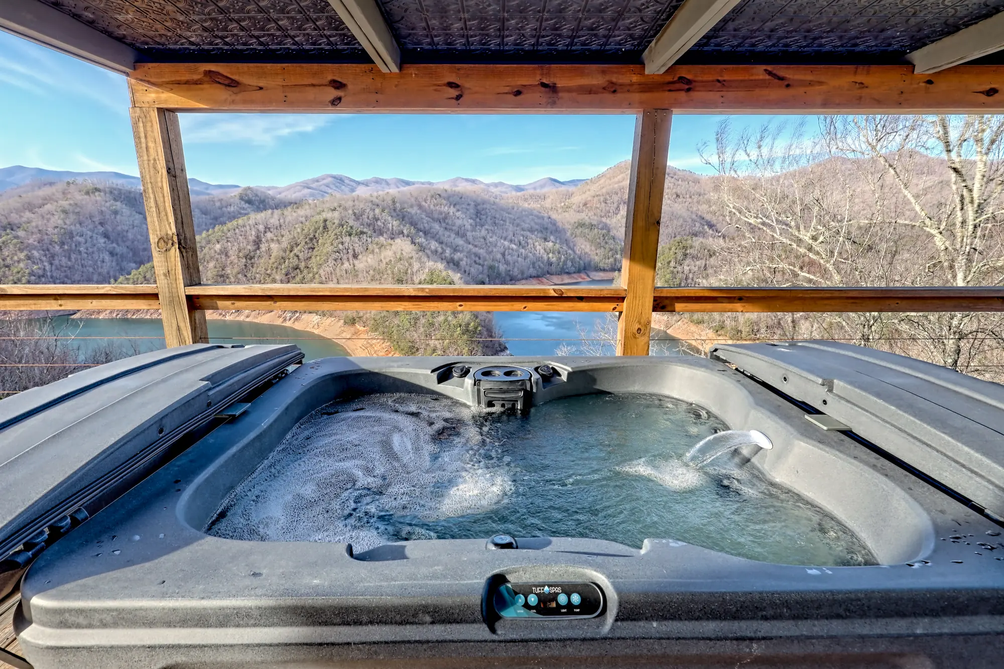 Tiny Tuck hot tub under a covered deck, looking down on Fontana Lake and layered mountain ridges