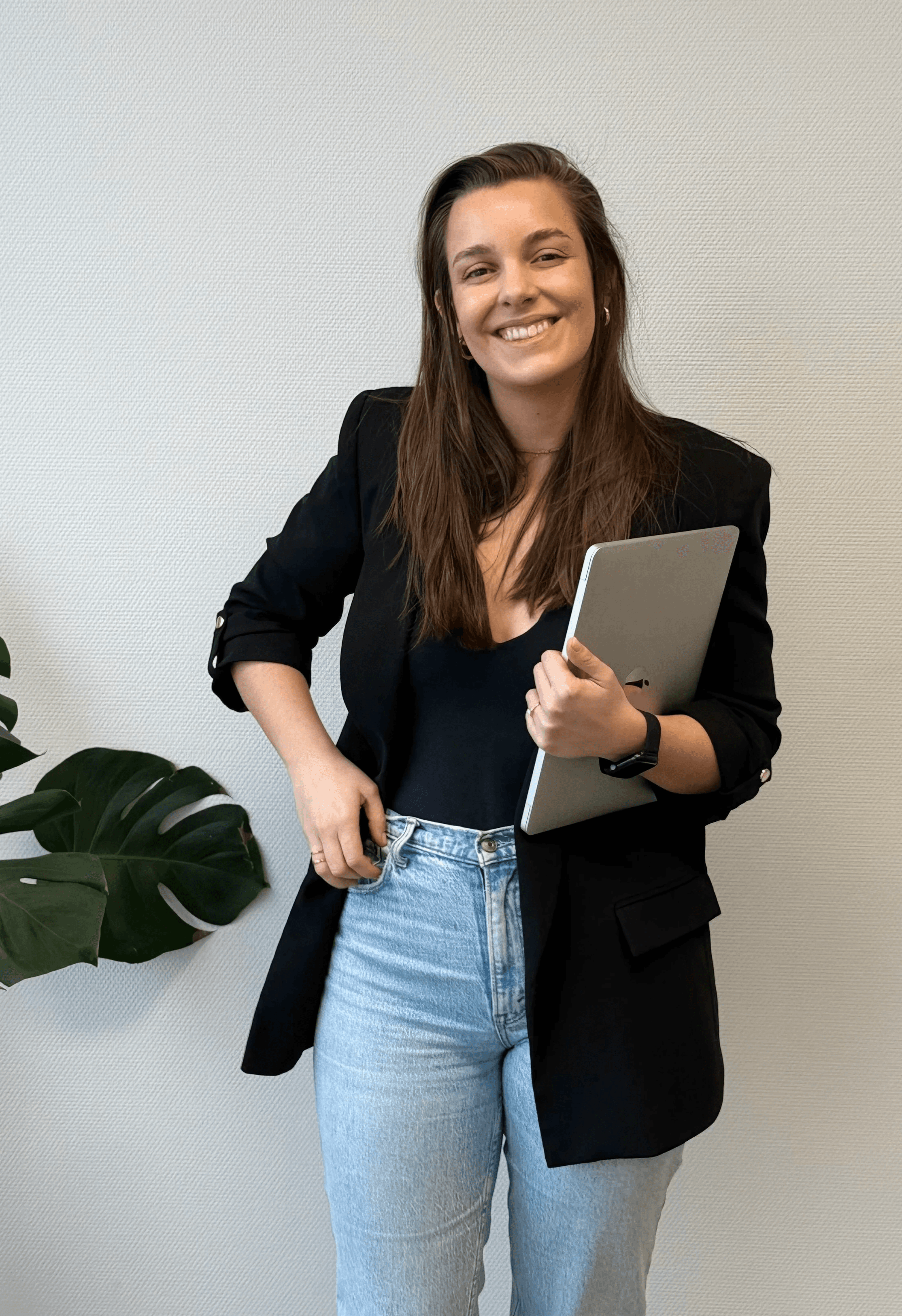 Sofia smiling to camera with a laptop on her arm.