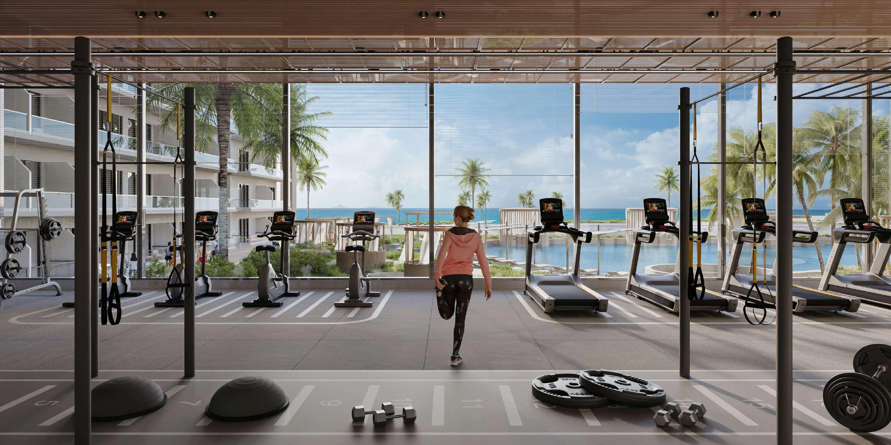 A gym interior featuring large windows that showcase a stunning ocean view, creating a serene workout environment.