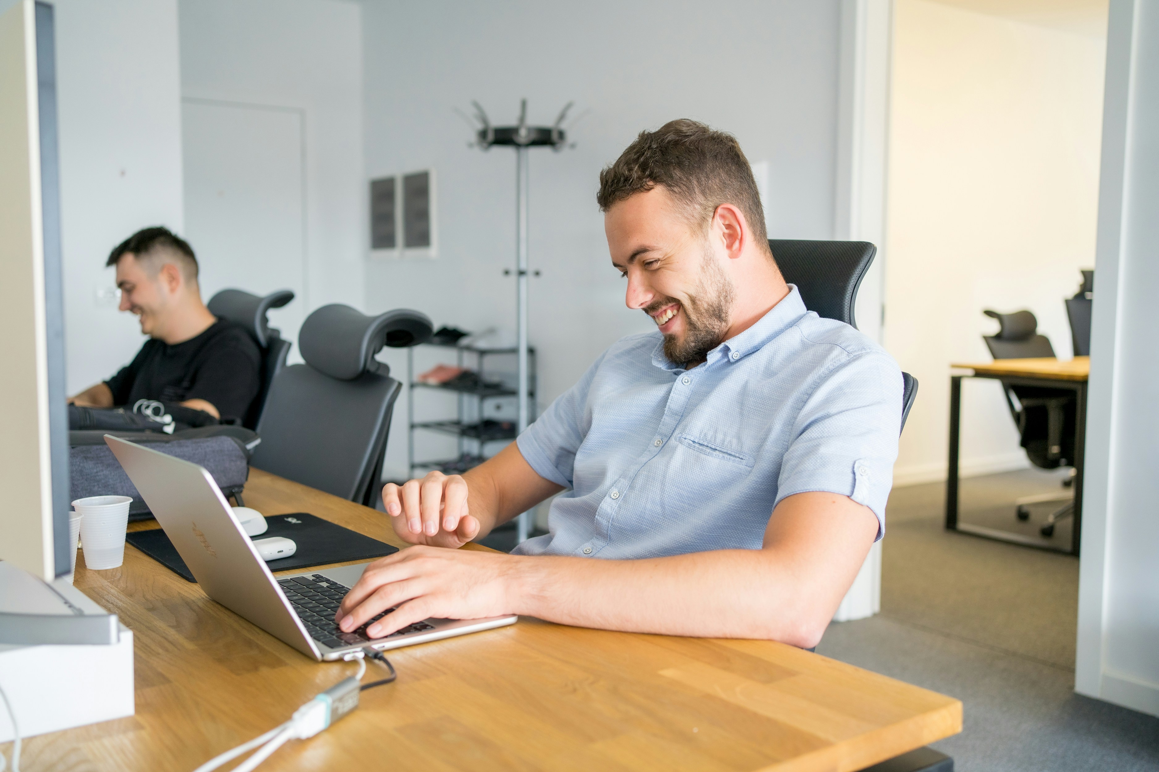 man smiling on his laptop - Unriddle AI Alternatives