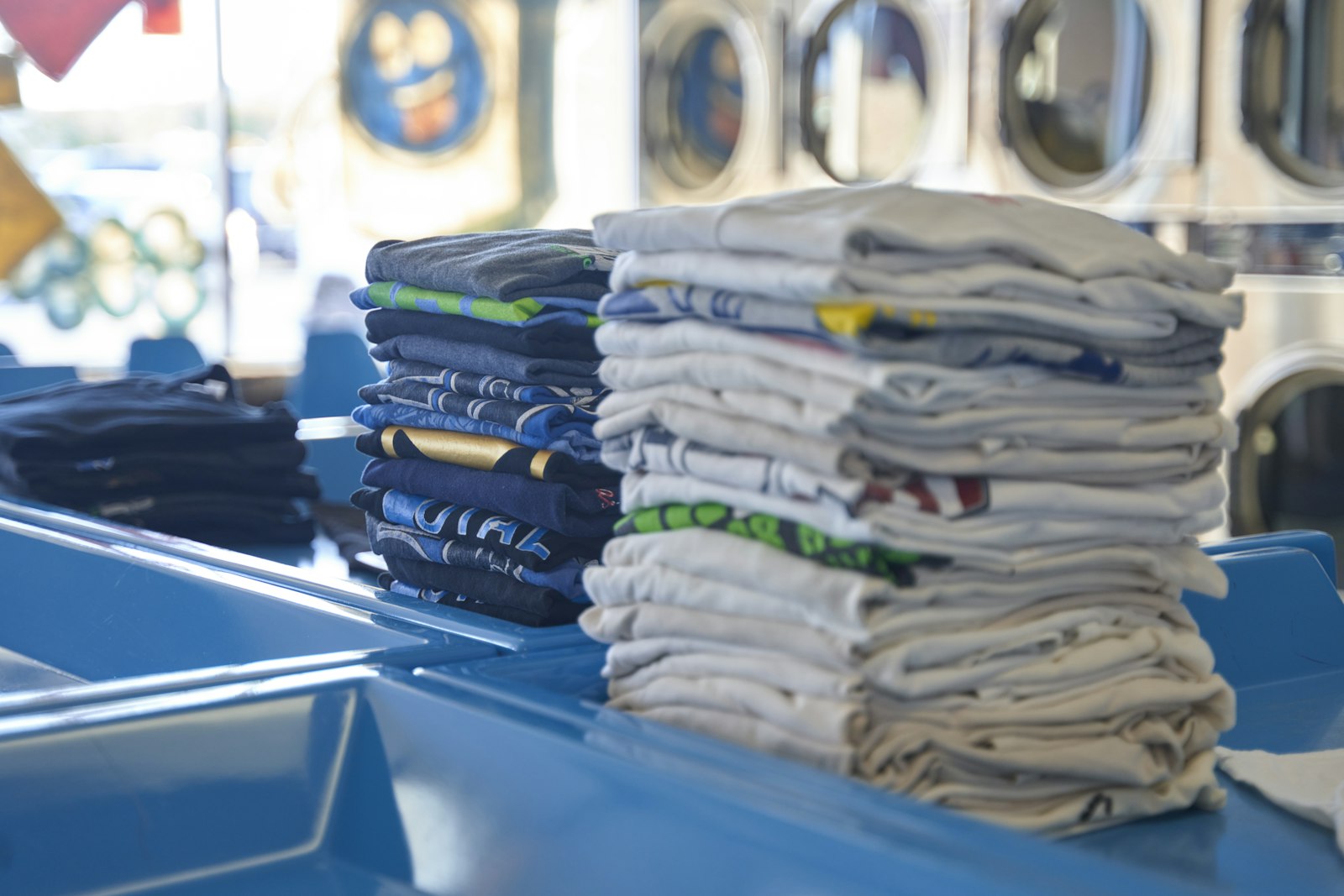 Stacks of folded garments on a laundry counter