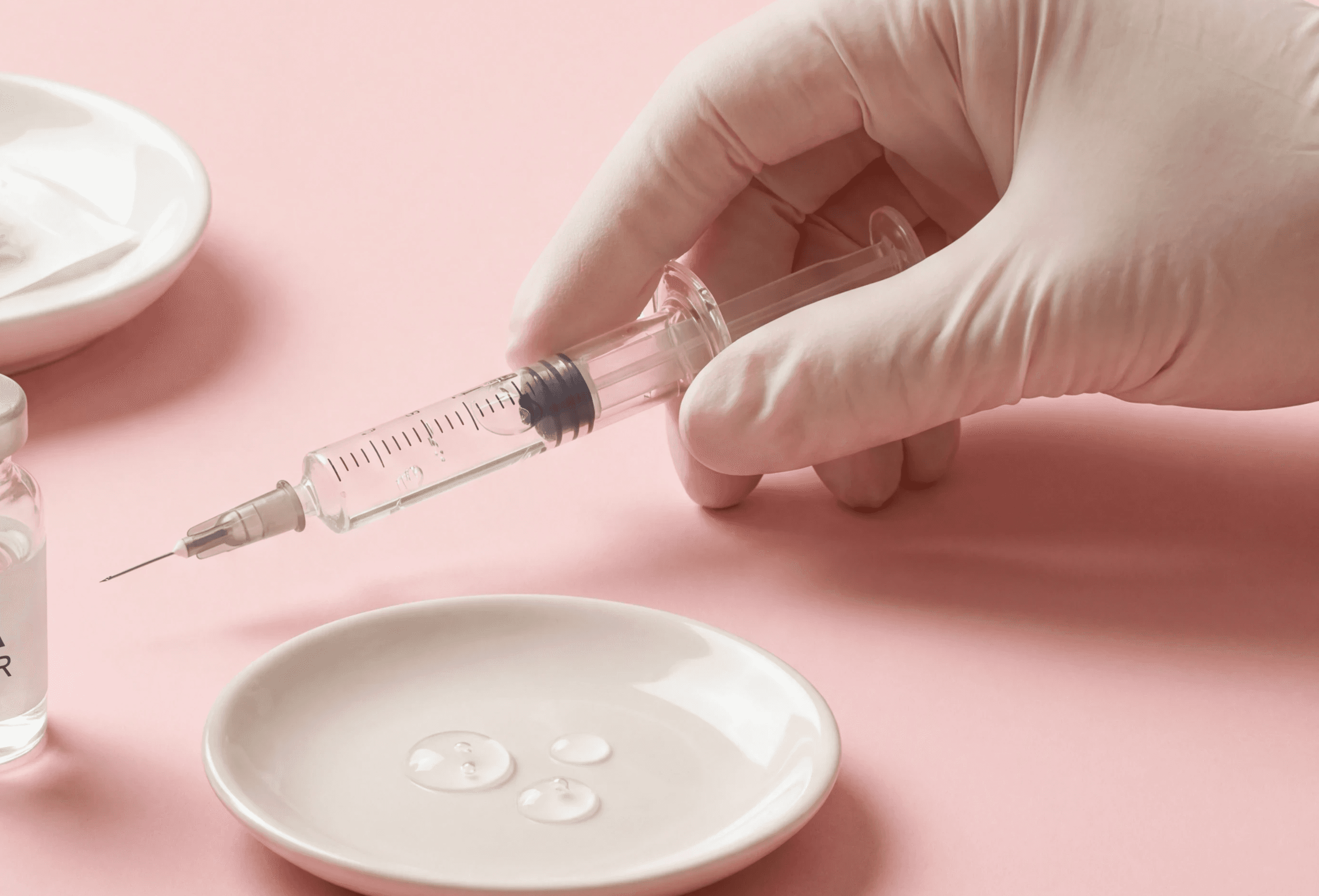 Spuit voor een fillerbehandeling in een hand met witte handschoen