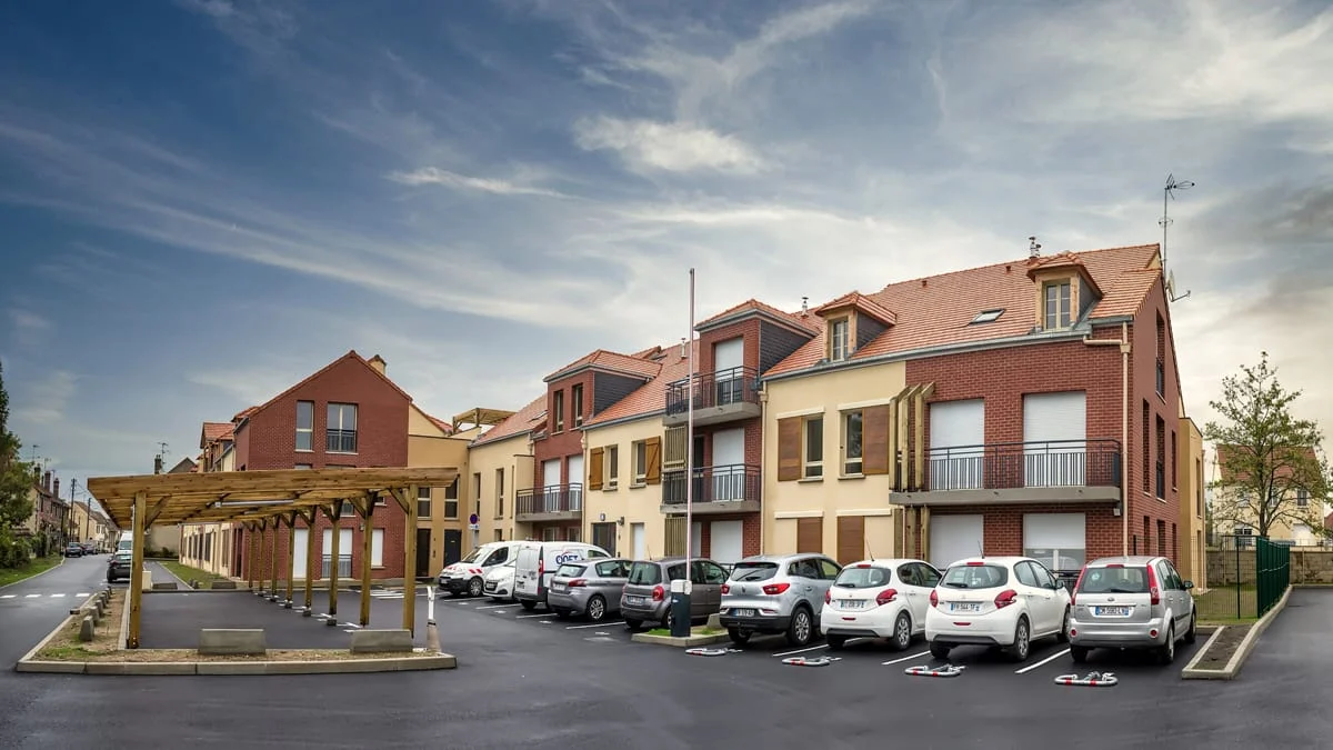 Résidence neuve en briques et enduit avec parking et pergola — photo immobilière Novalys
