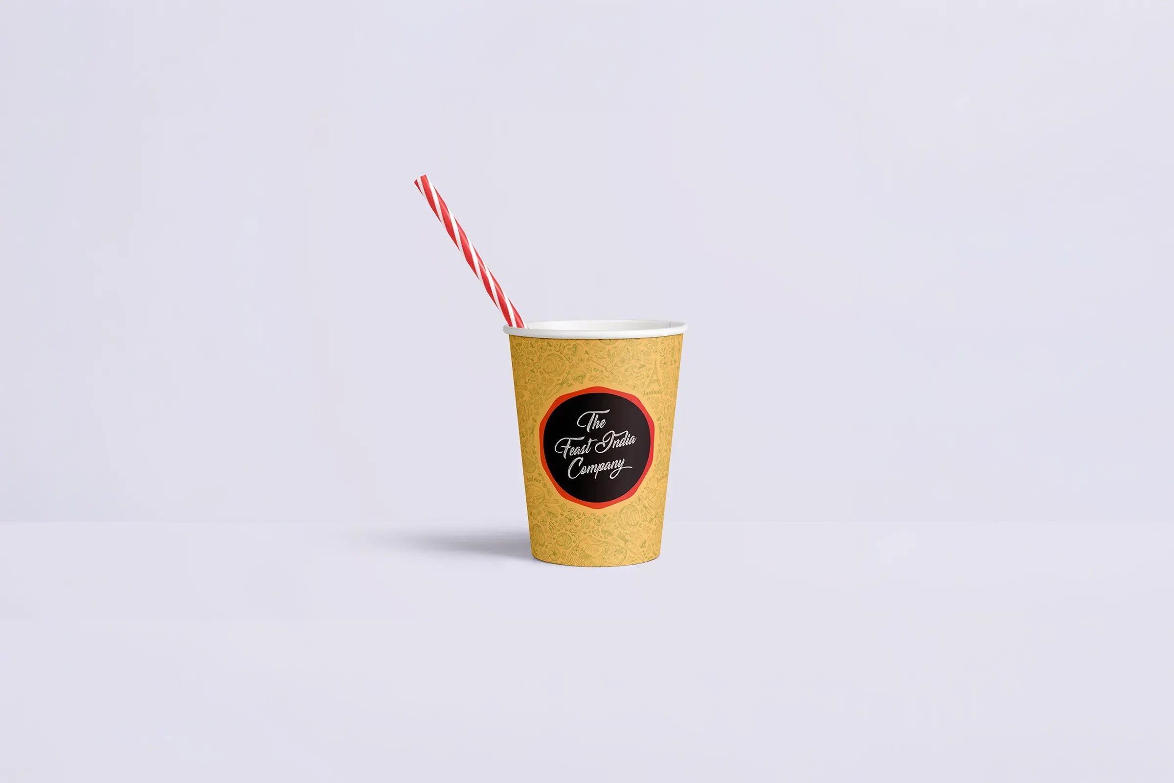 A speckled yellow takeaway coffee cup with a red-and-white striped straw and black café label sits alone on a pale background, calm and minimal.