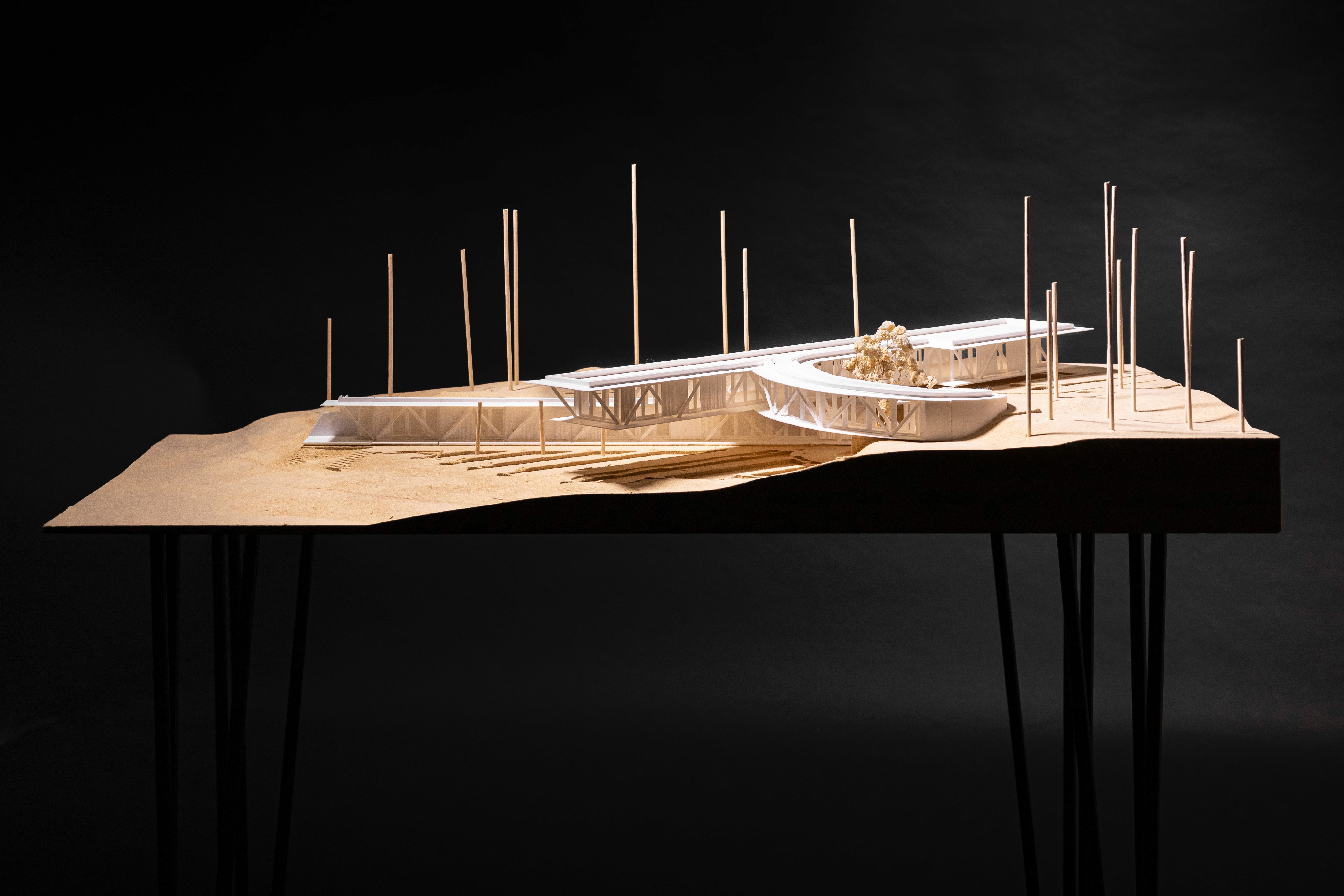 Physical concept model milled out of mdf with a 3D printed massing and steel legs.