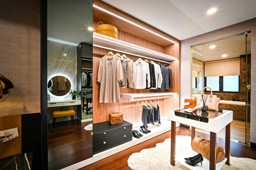 A walk-in closet with white cabinets and a chandelier