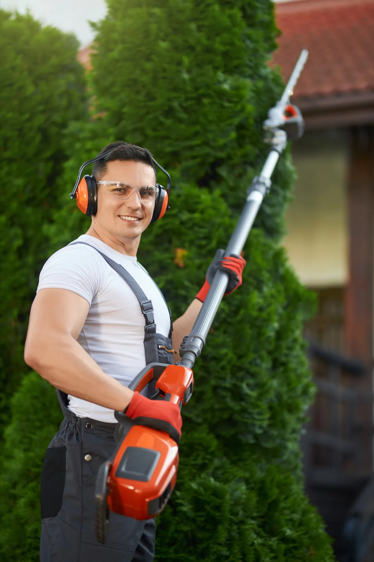 man with hedge trimmer performing northside brisbane property maintenance